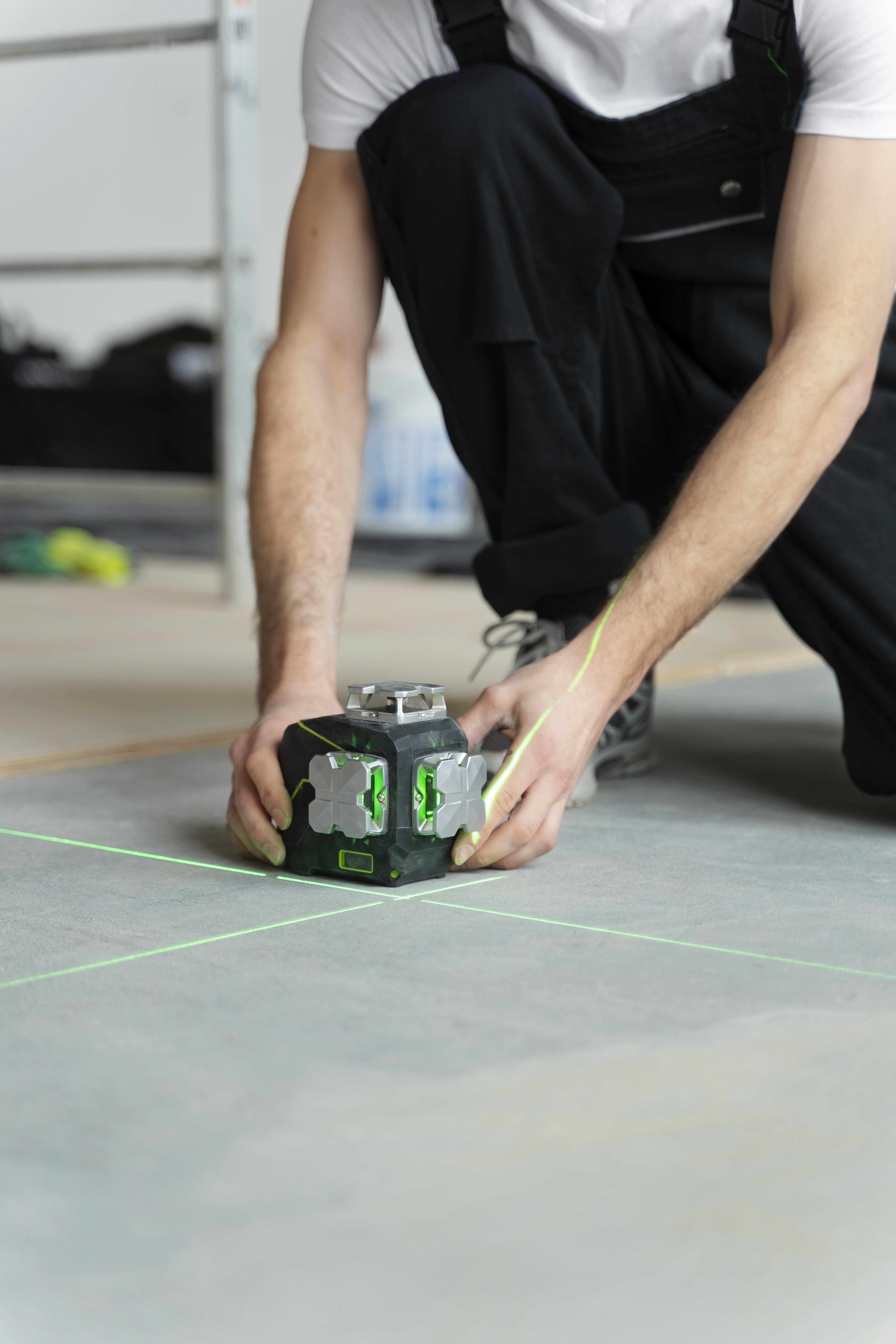 Installer using a laser level to ensure a perfectly flat subfloor, preventing uneven flooring and long-term movement.