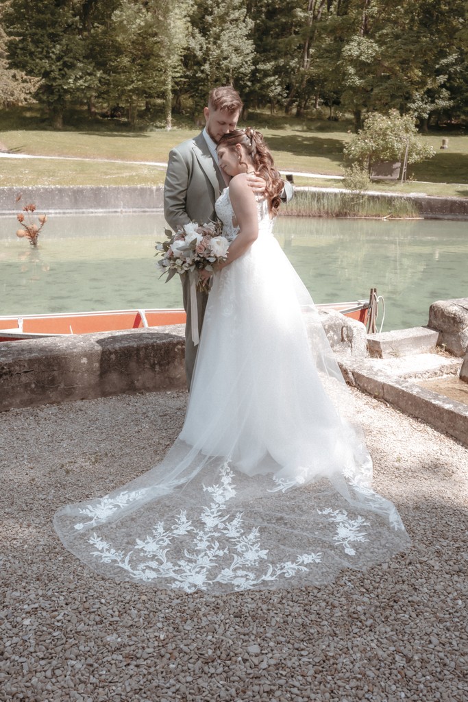 Elegant outdoor wedding table with crystal glasses and floral arrangements bathed in soft sunlight — fine art event photography. Table de mariage élégante en extérieur avec verres en cristal et compositions florales baignées de lumière douce — photographie Fine Art d’événement.