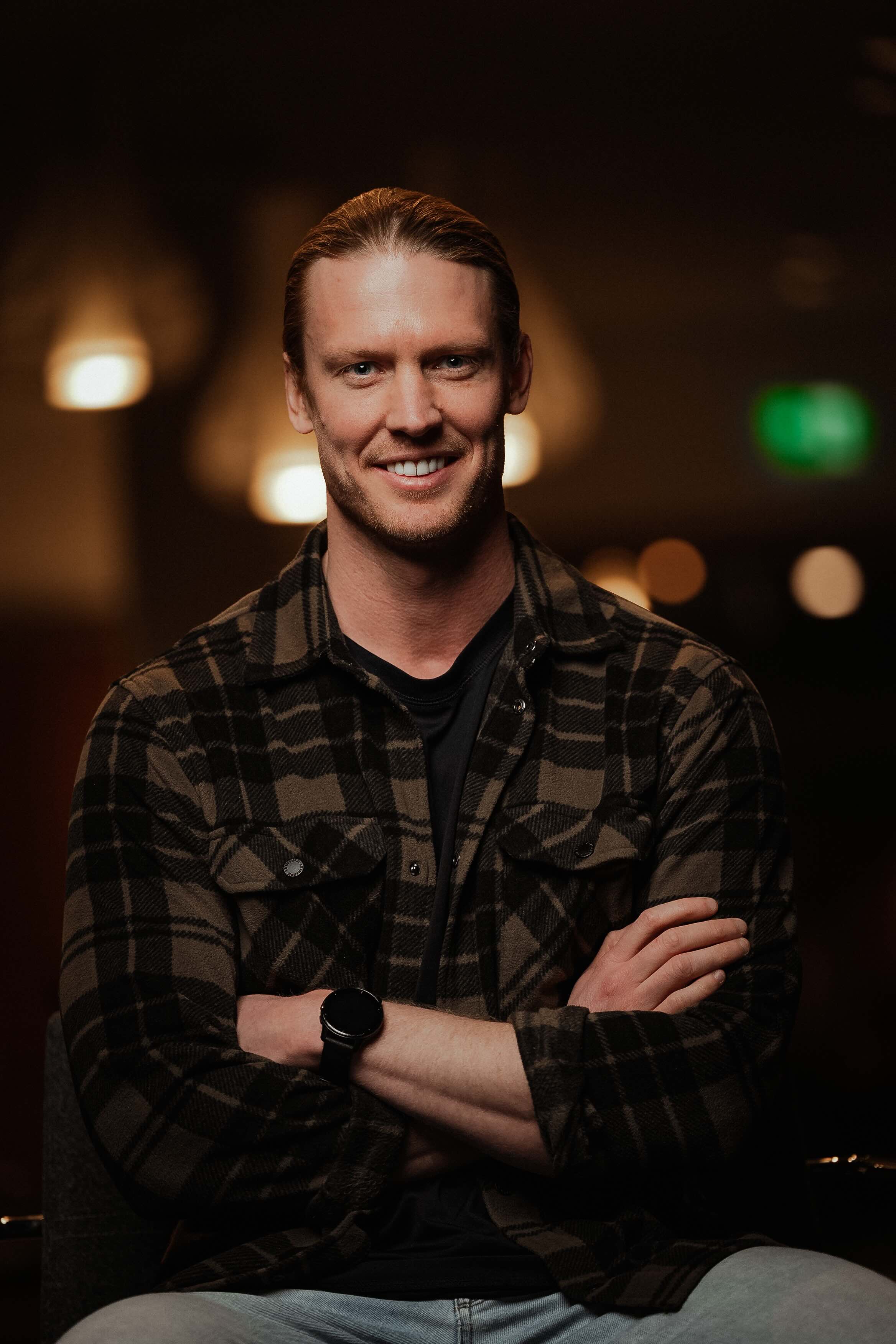 A basketball player in a white uniform jumps for a layup while a defender in a black uniform attempts to block the shot.