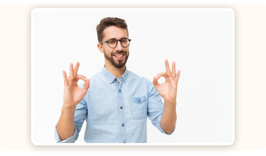 Smiling man making OK gesture with both hands on white background