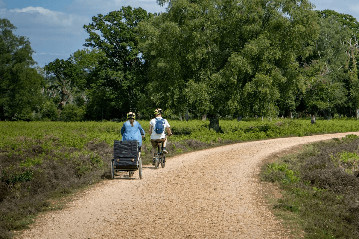 Two recreational cyclists riding together on a gravel path