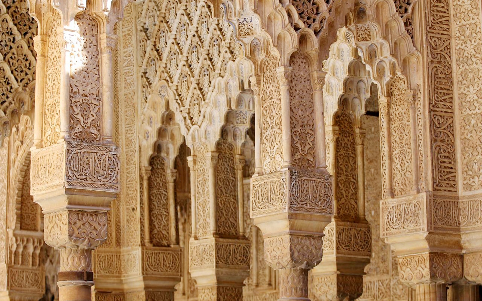 Intrikate mauriske buer i Nasrid-palassene, Alhambra, Granada.