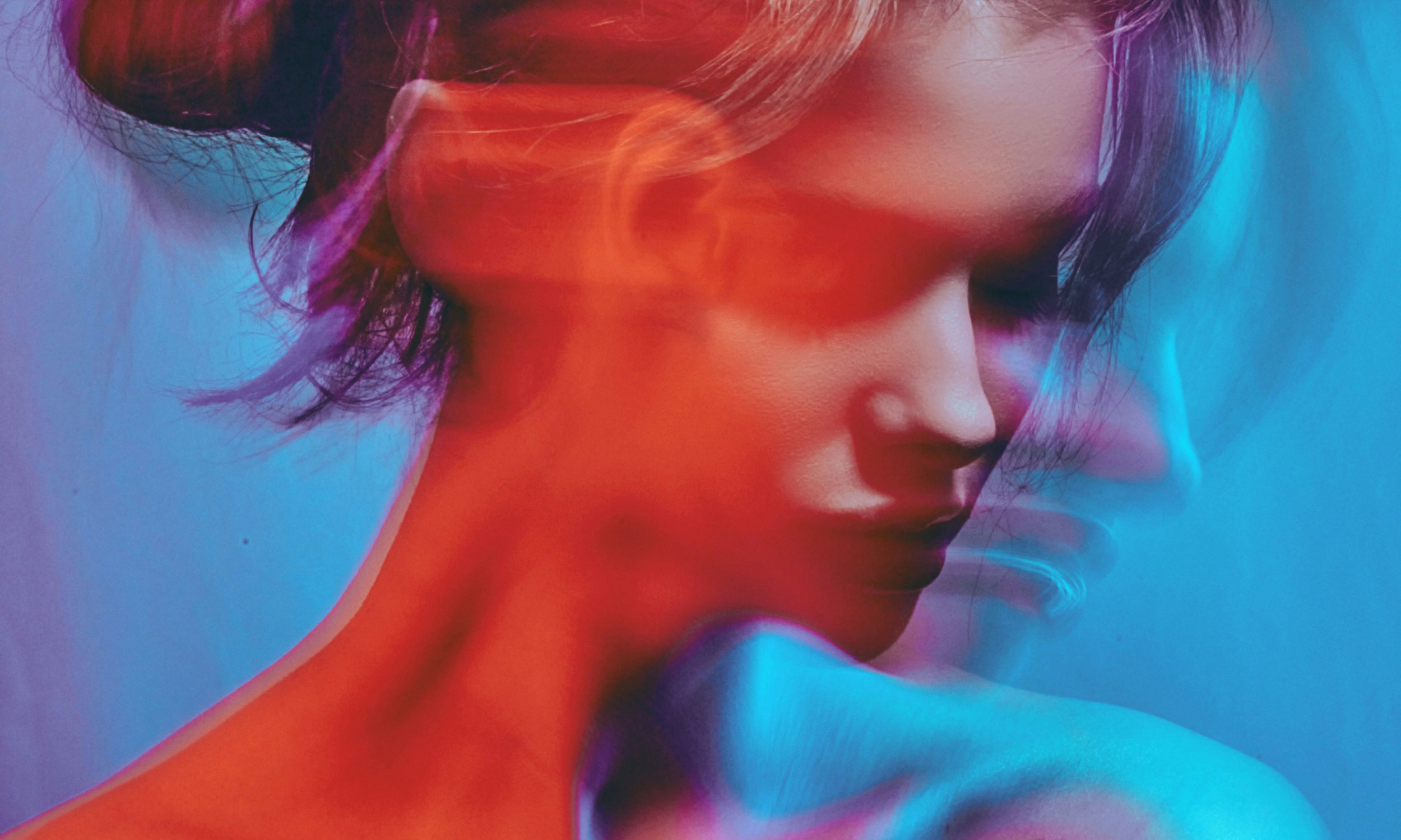 Artistic portrait with red and blue lighting creating a dramatic effect