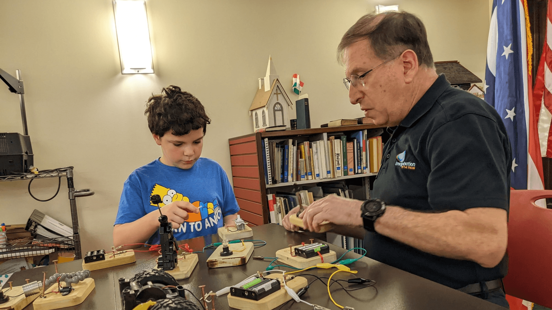A volunteer and boy collaborate to create a circuit block.