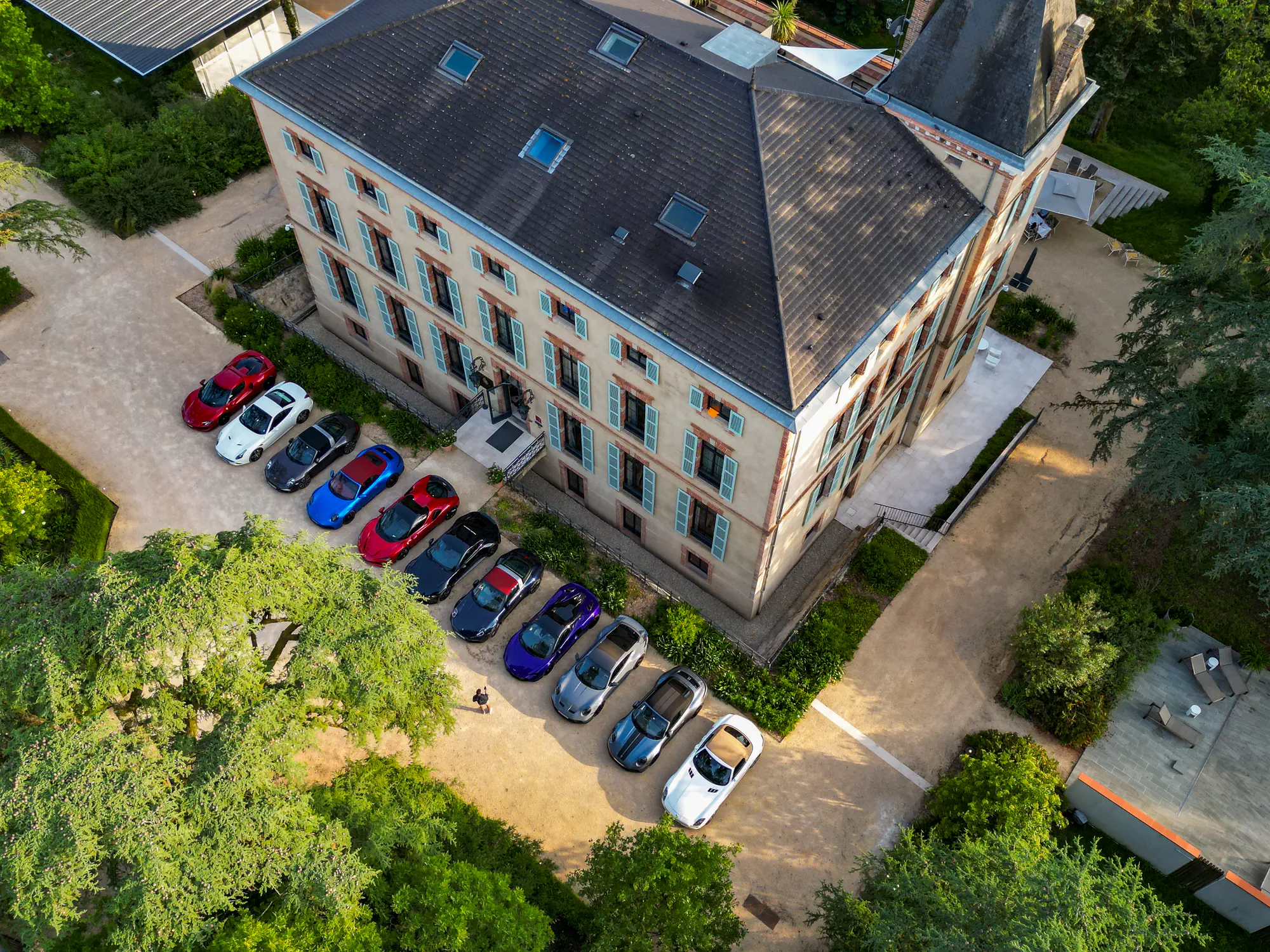 Vue aérienne d’une grande demeure et des voitures du groupe garées devant