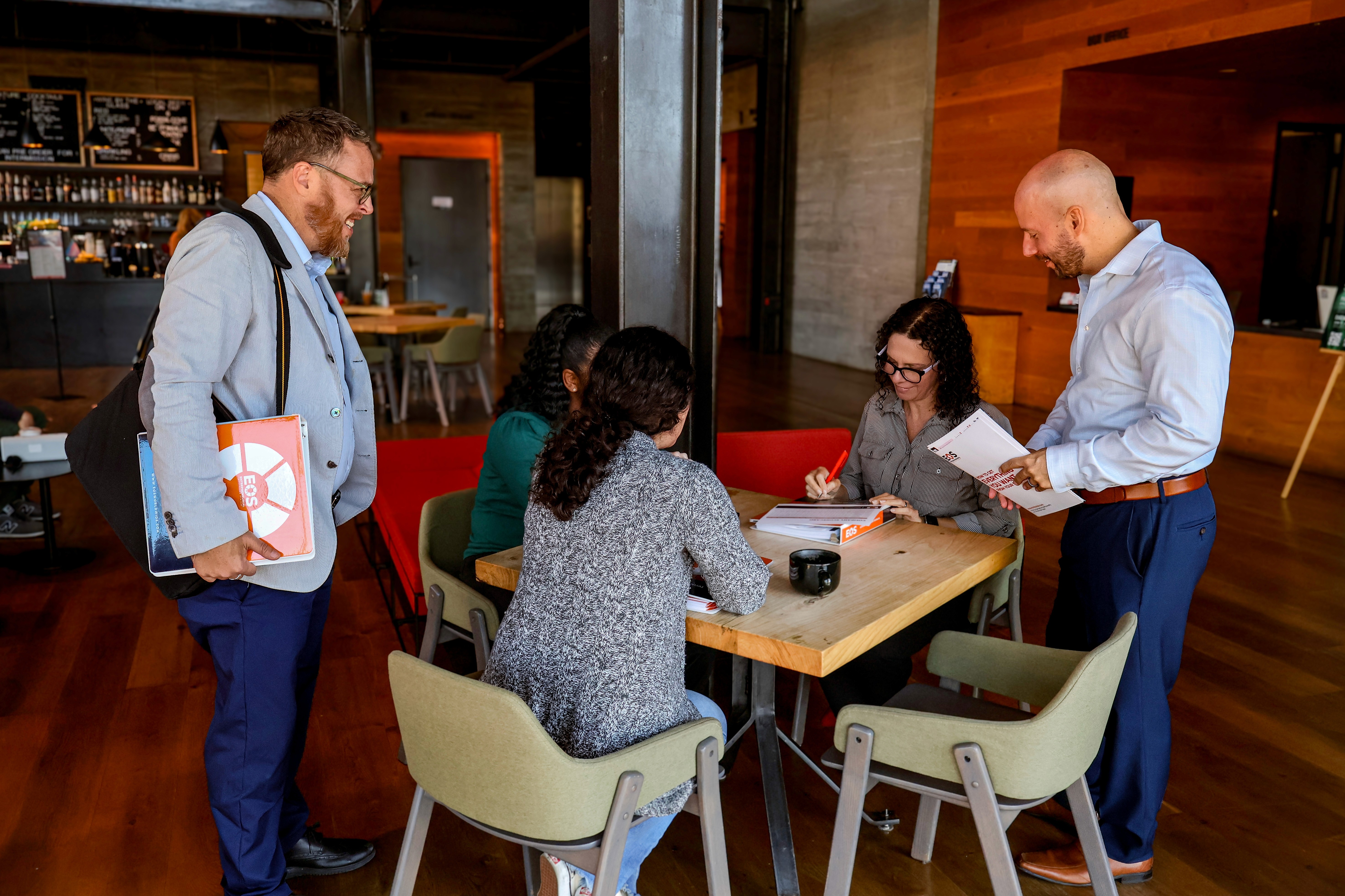 A blank white card resting on a softly draped rust-colored fabric atop a beige quilted surface.