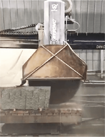 The Dinosaw Bridge Cutting Machine cutting a stack of stone blocks, highlighting its capability to handle multiple pieces simultaneously.