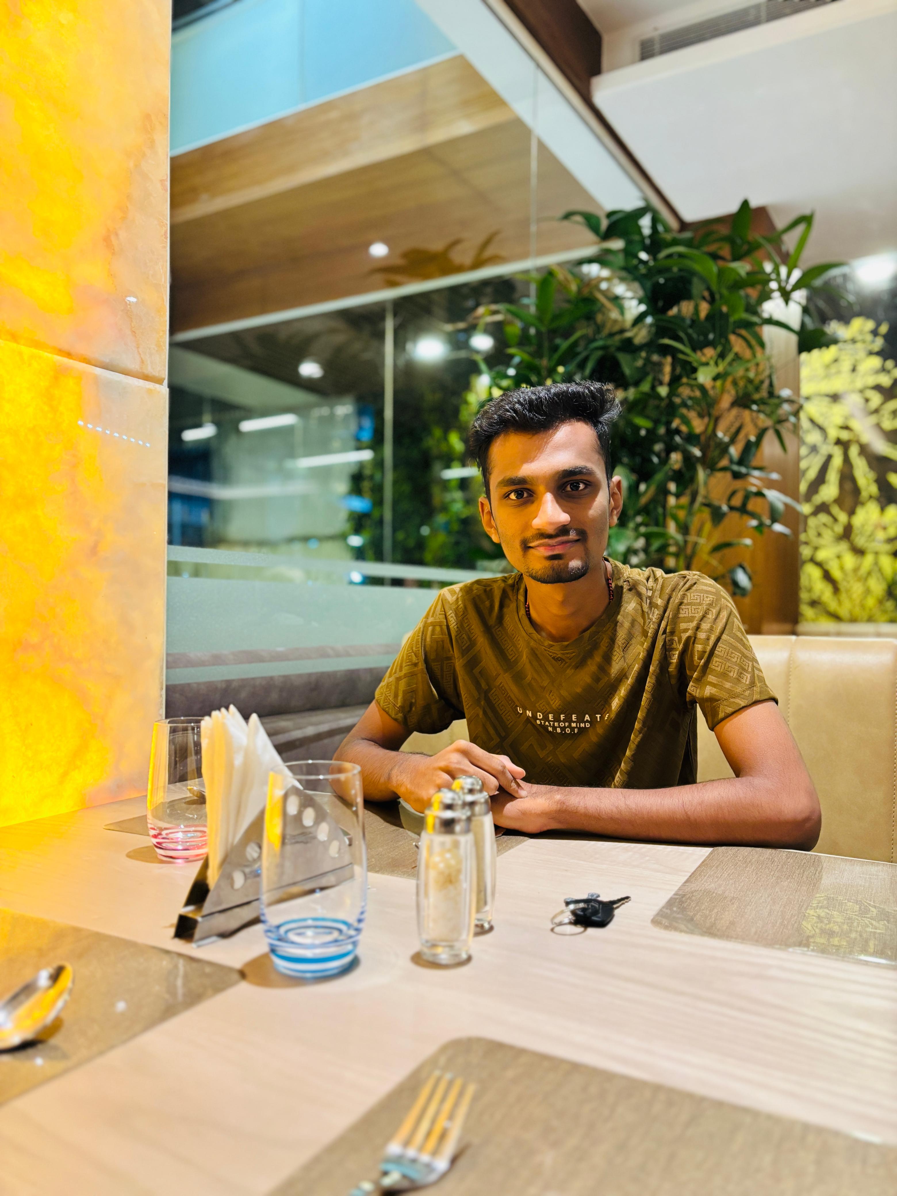 a man wearing glasses and a blazer with a lighting that casts a soft shadow on the wall behind him