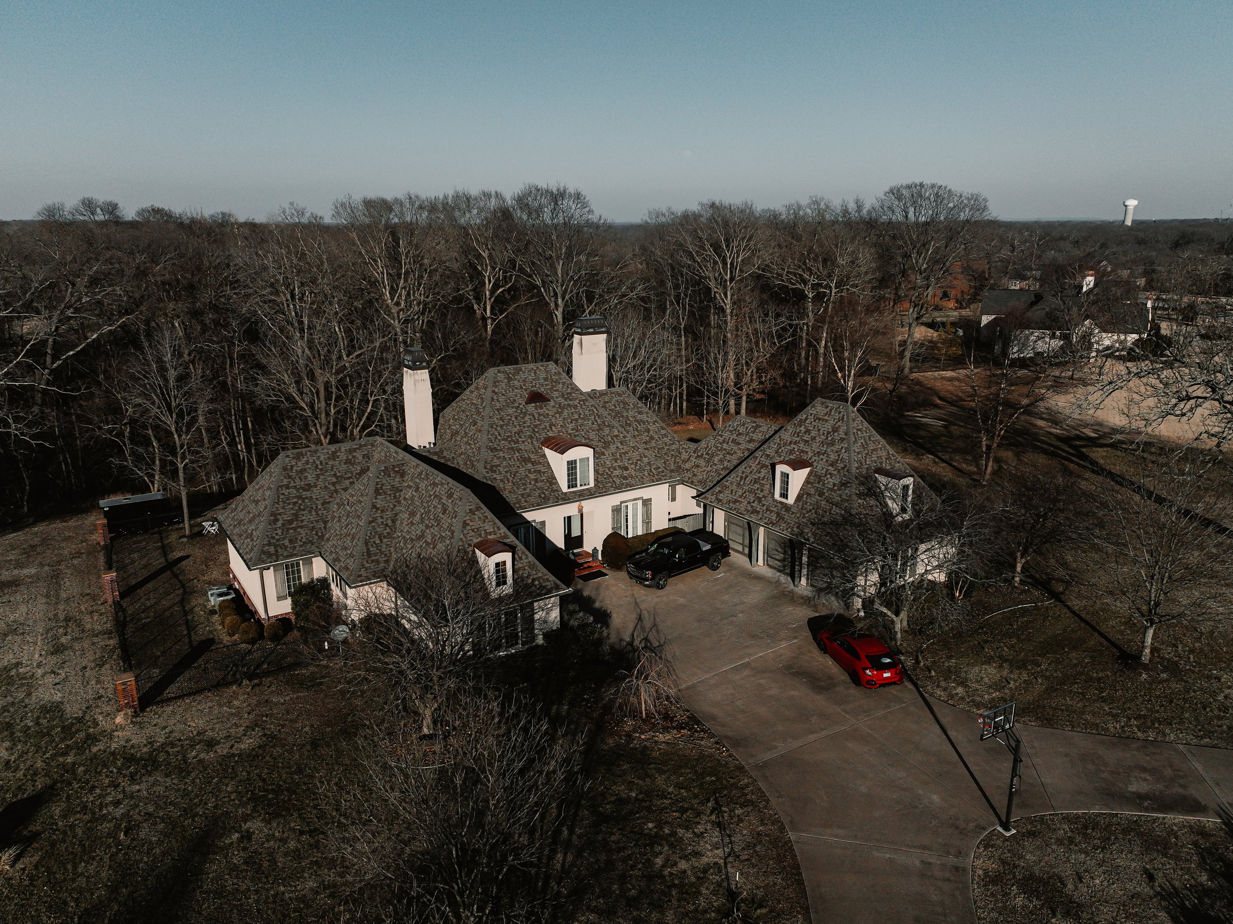 Aerial view of a white house in the woods