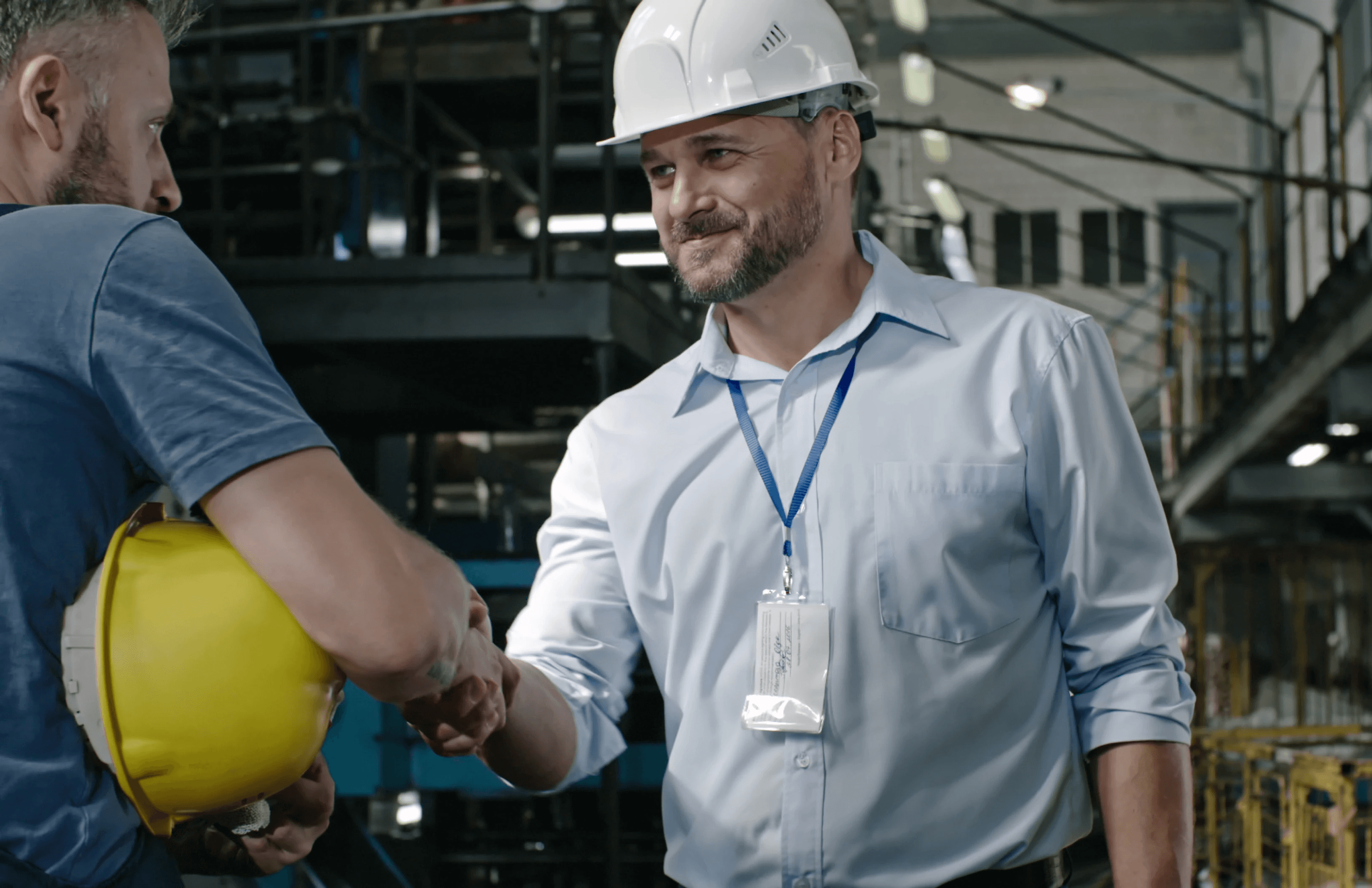 Two men in a prefab shop looking at a laptop