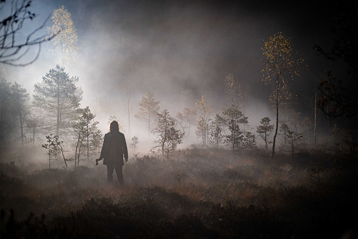 Scene from The Bog, showing Madjak, the menacing villain, standing in the dark. A tense Estonian WW1-era drama based on Oskar Luts’ novel about love, fear, and moral conflict.