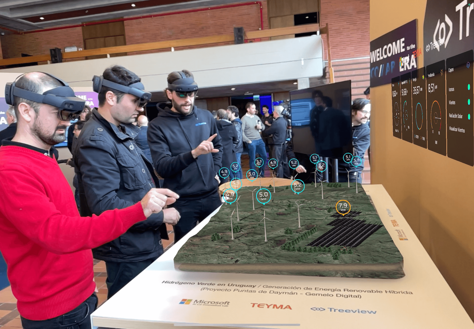 Three engineers wearing HoloLens headsets reading a mixed reality digital twin of a hybrid renewable energy project in Uruguay
