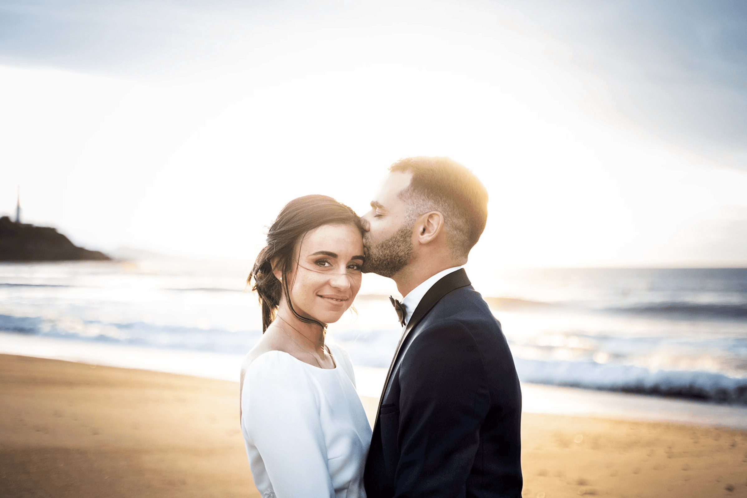 le couple de mariés s'embrasse à la plage devant l'espace de l'Océan à anglet au pays basque