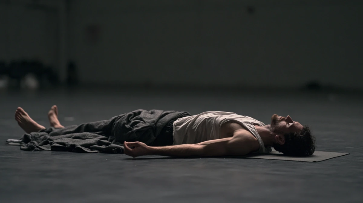 Man resting on his back in silence after a breathwork session, blanket over his legs