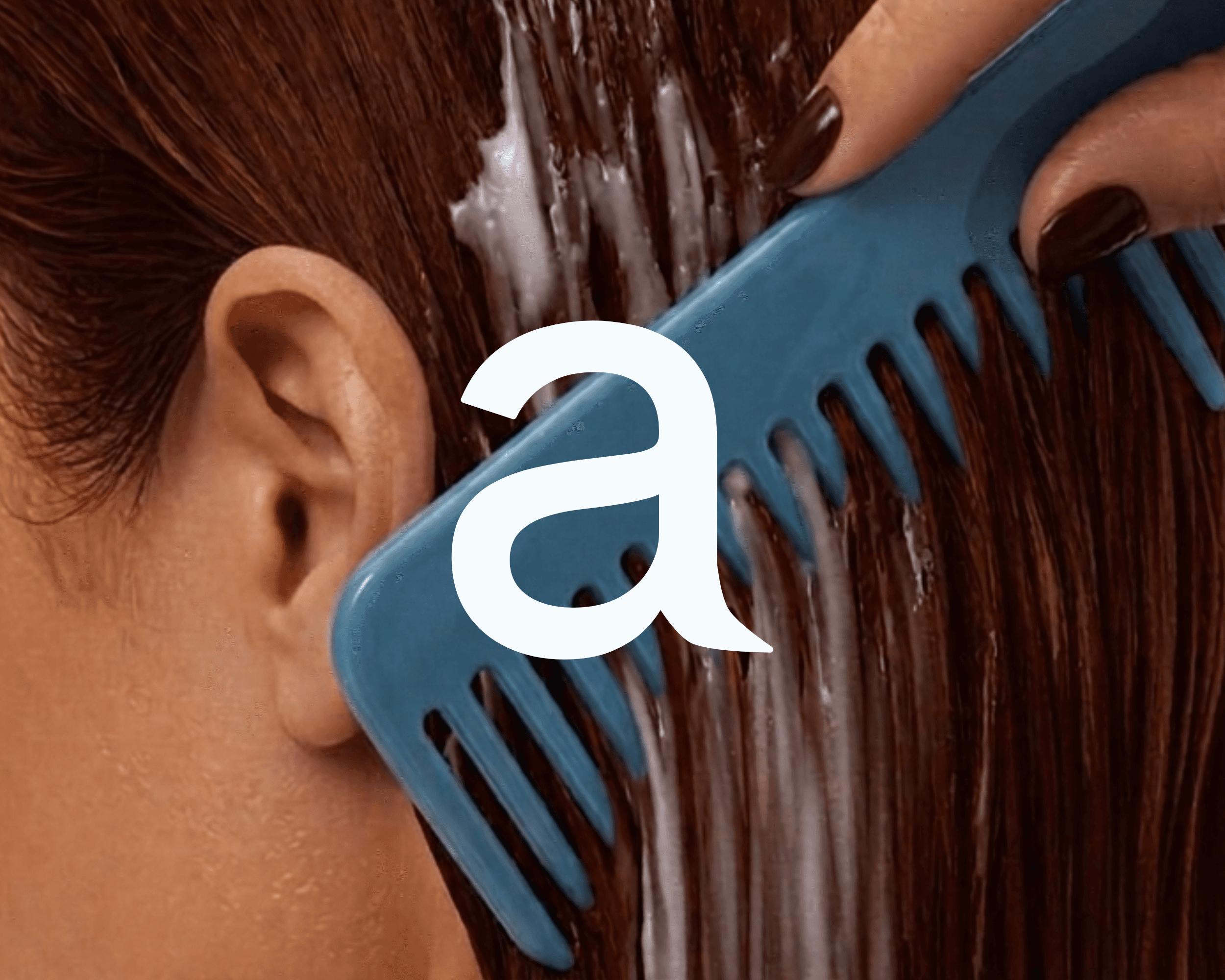 A photo of a red-headed woman brushing a blue comb through her hair. The Aurelia Haircare logo is featured in the middle of the image.