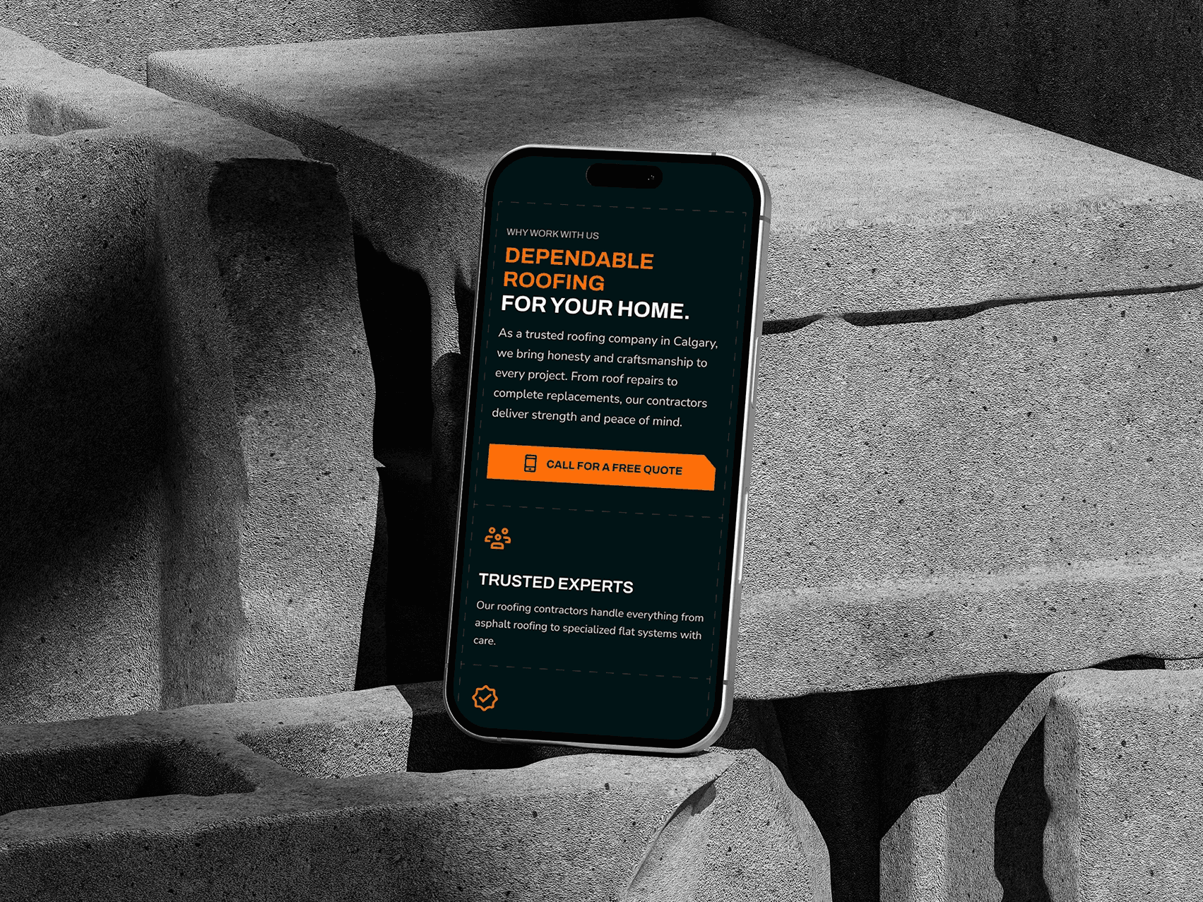 A smartphone leaning against stacked concrete blocks displays a roofing company's website with bold text reading “Dependable Roofing for Your Home.” The screen highlights services in Calgary, including repairs and replacements, with a bright orange button inviting users to call for a free quote.