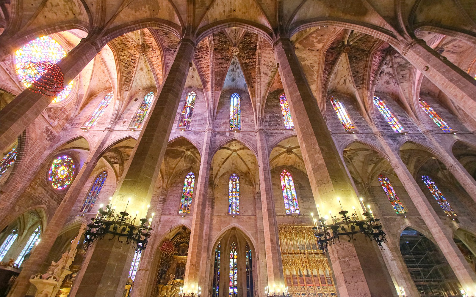 Interior de la Catedral de Mallorca con vitrales y techos abovedados.