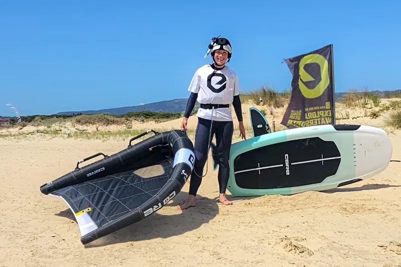 Wingfoil student posing with gear on the beach at Explora Watersports Tarifa