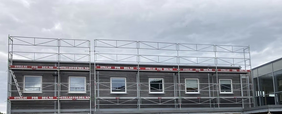 a man in a yellow shirt is working on a roof