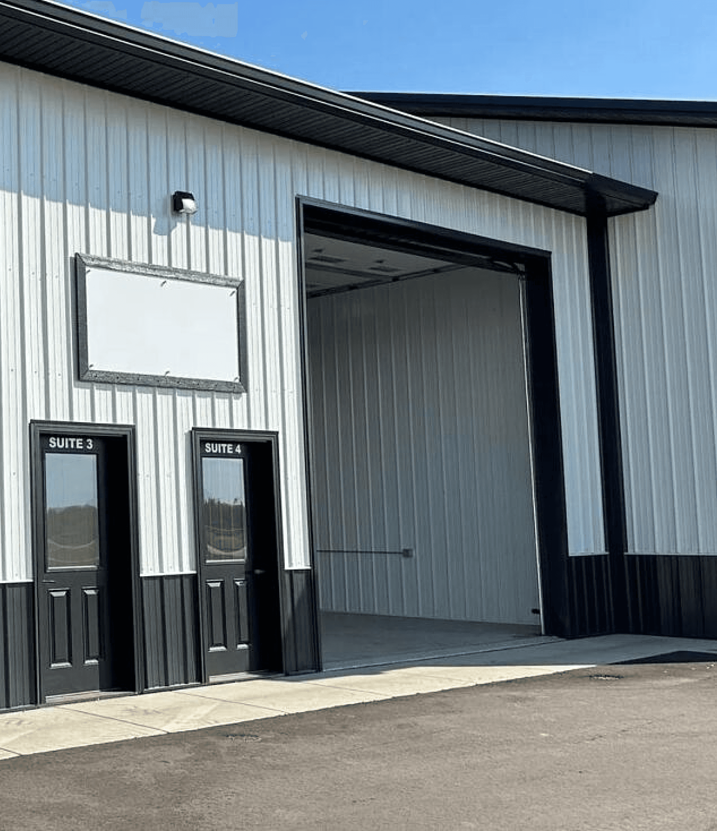Industrial building exterior with suite doors and large garage entrance.