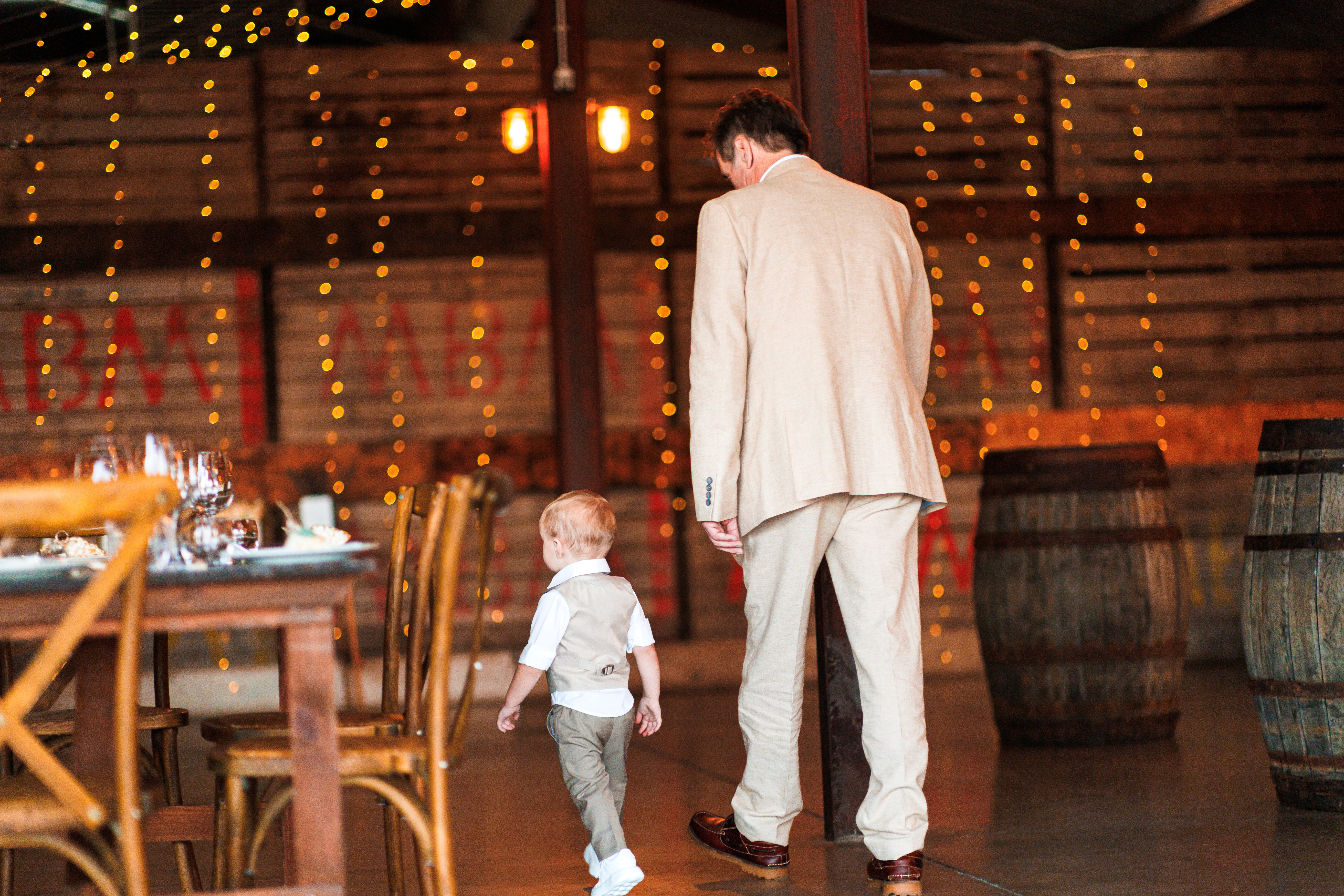 Chris walking hand in hand with a young child across Grange Barn’s reception room