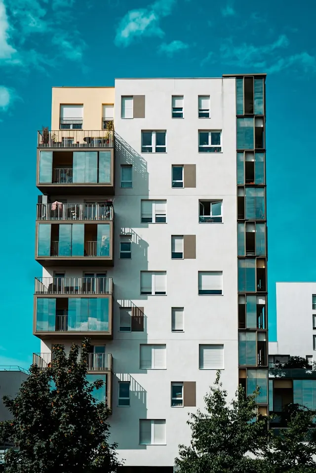 Fachada de un edificio de viviendas moderno con balcones acristalados escalonados, los elementos del continente comunitario que cubre el seguro de comunidad