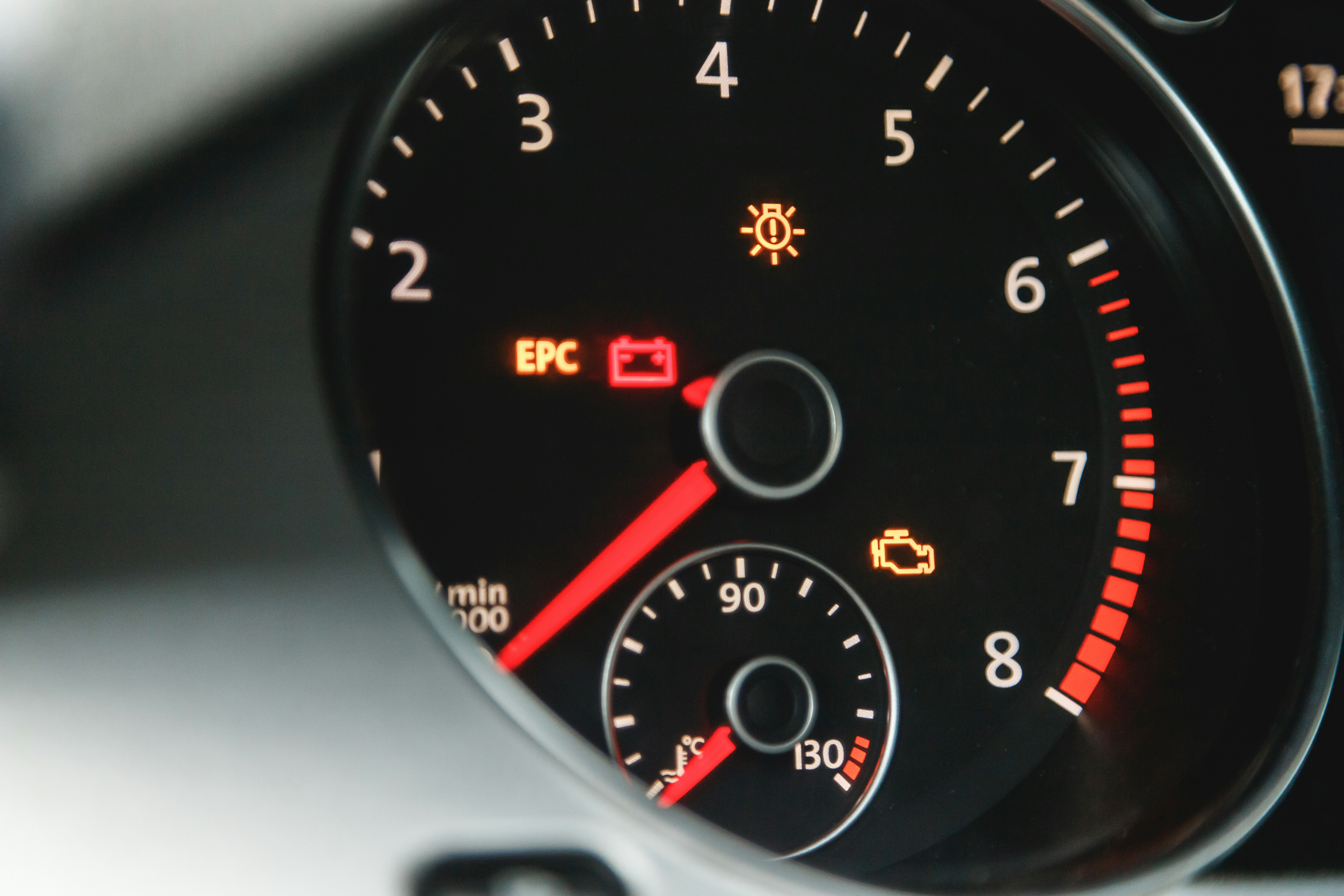 Car dashboard showing illuminated check engine light and warning indicators