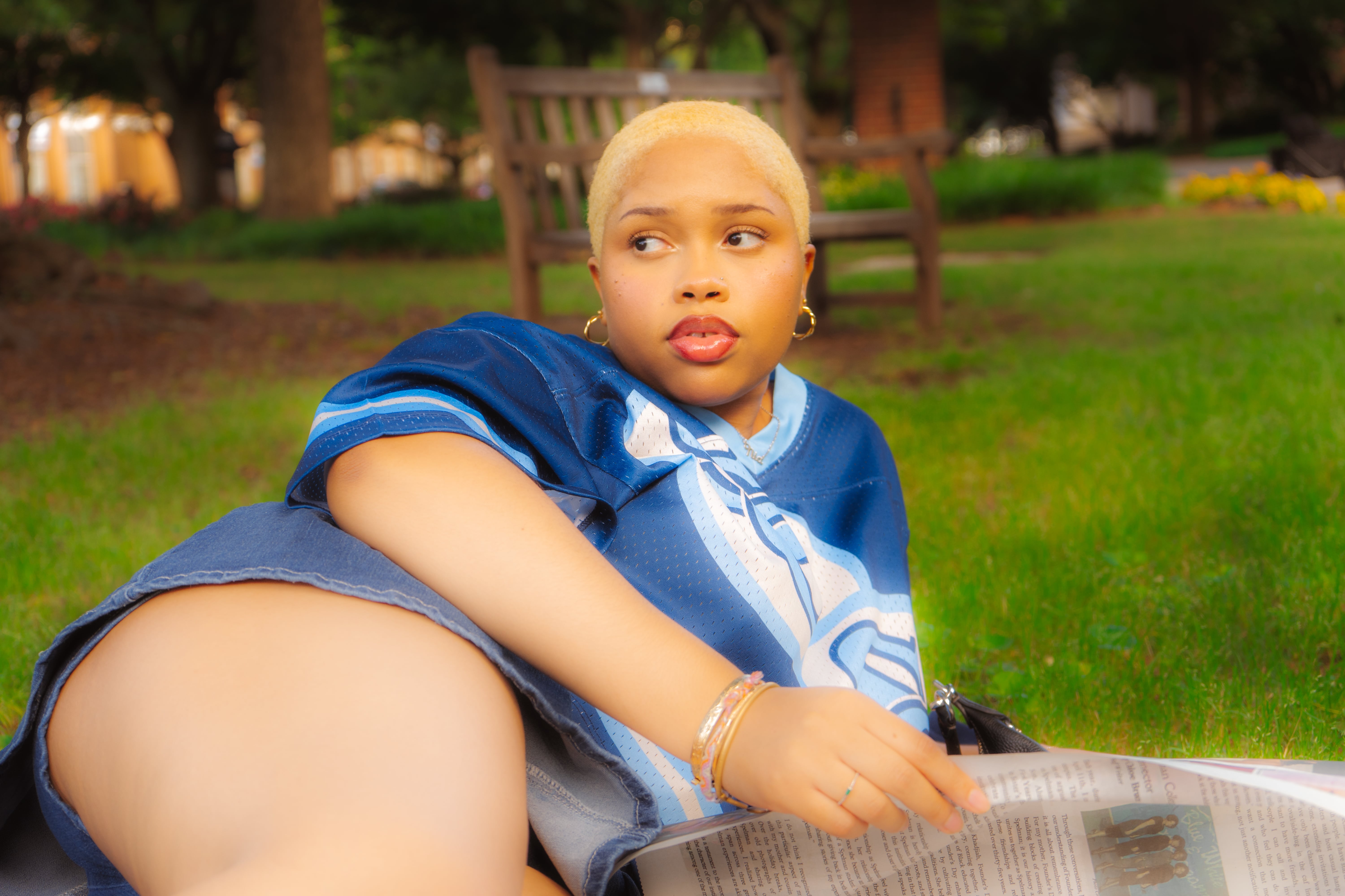 Woman in red outfit poses by a red telephone booth.