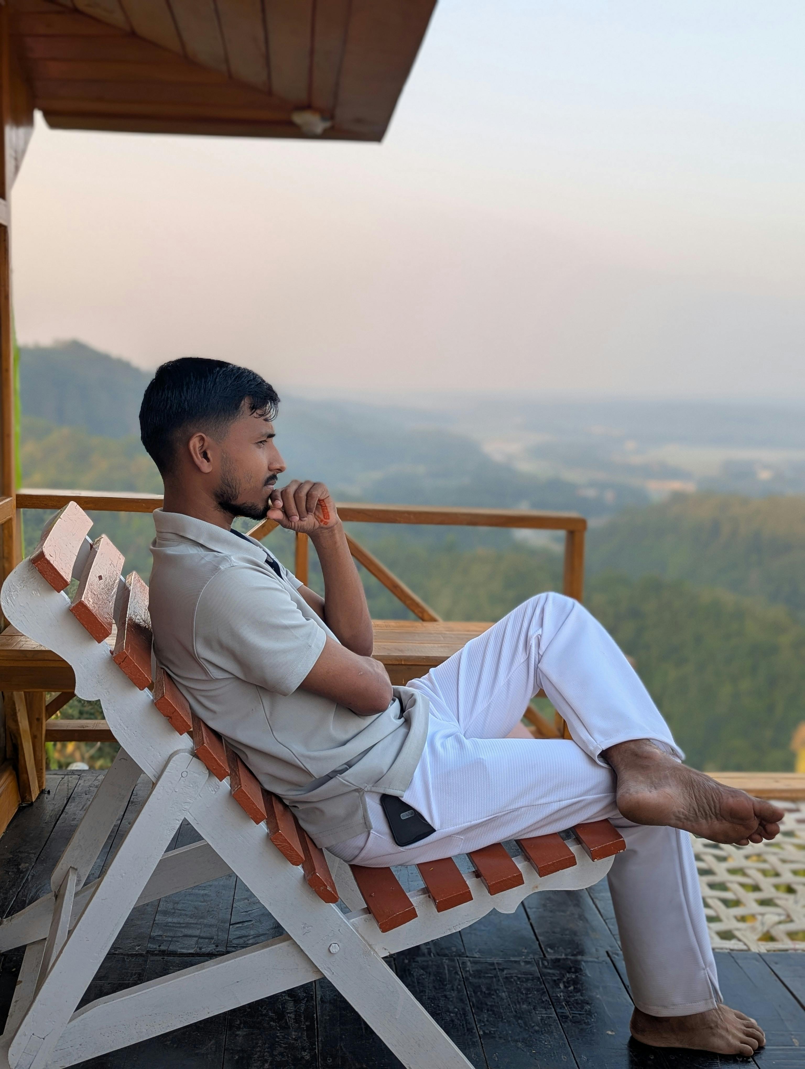 Man Relaxing on Mountain Balcony, the person appears to be thinking