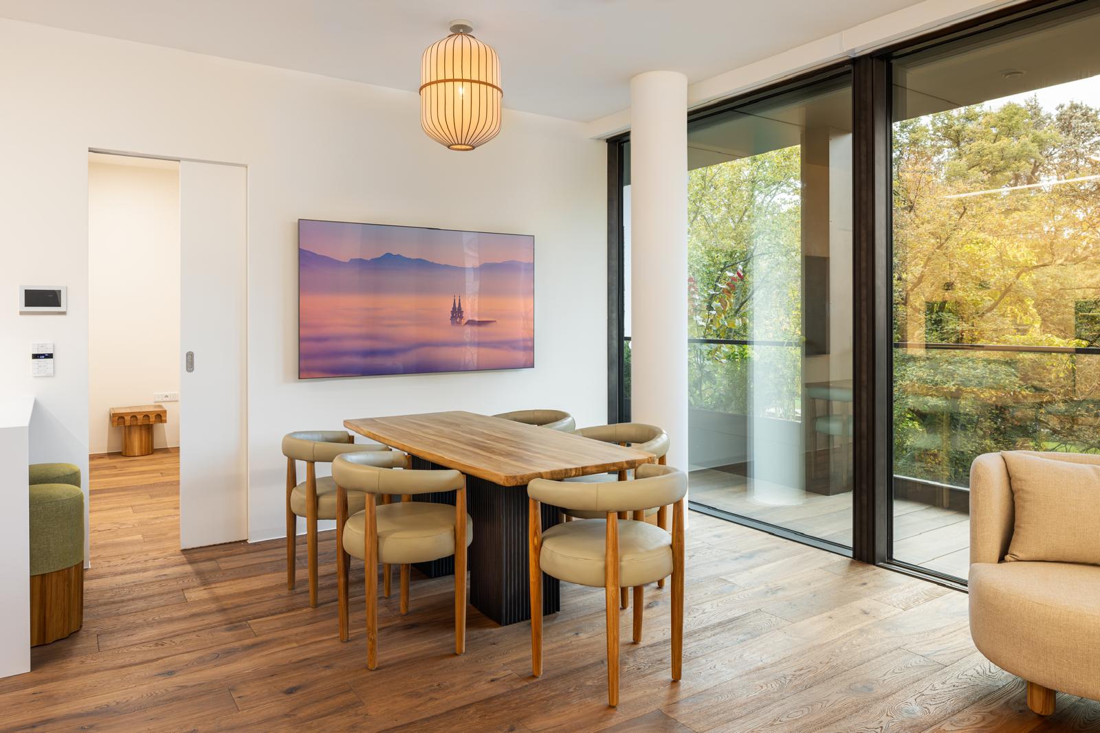 Helles Esszimmer mit großem Esstisch und Stühlen in einem der Apartments von Bloom Living in Linz