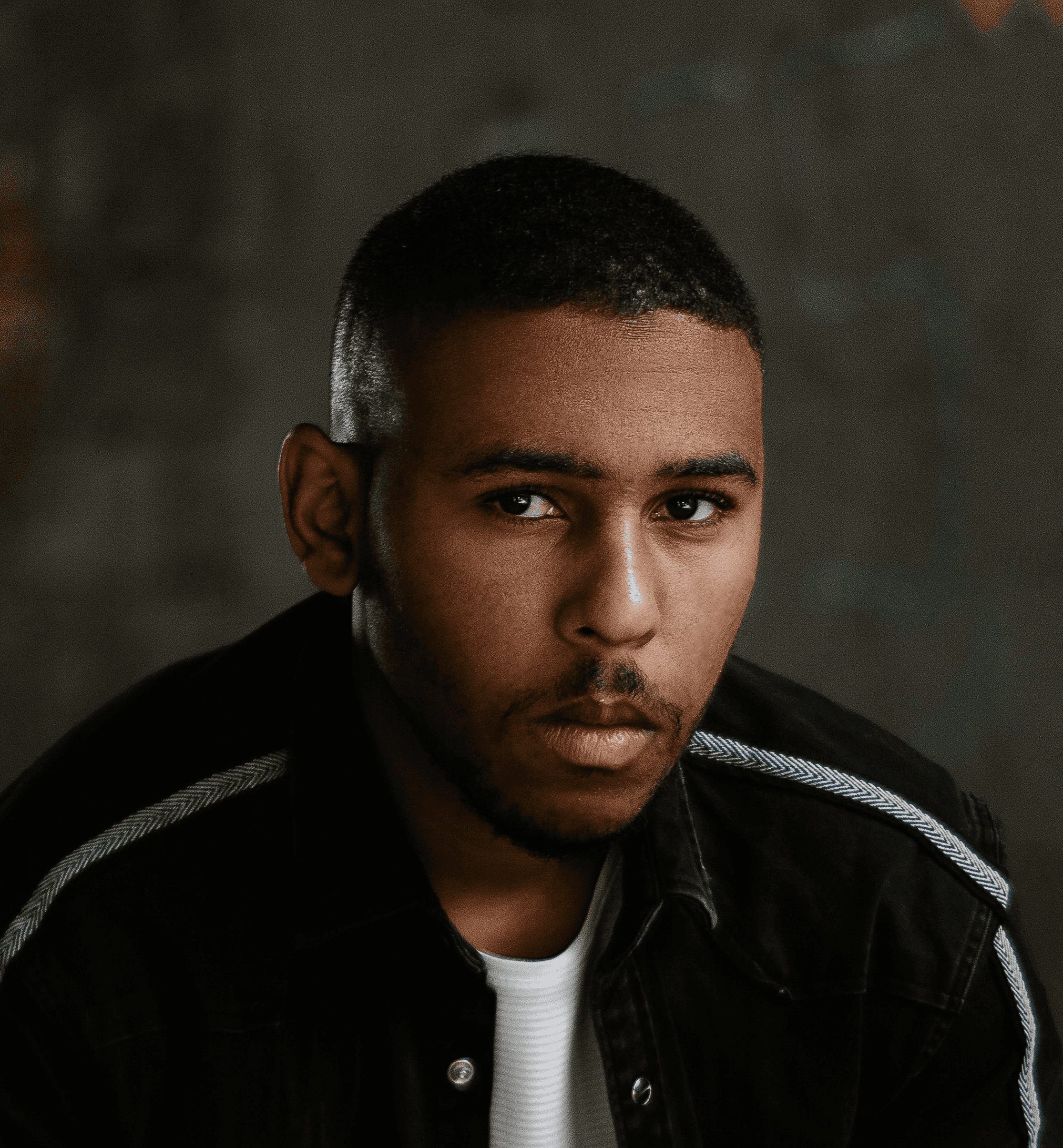 a man in a black jacket is sitting down