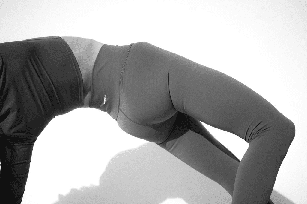 Woman in a bridge pose in soft studio light, movement and body awareness that support libido