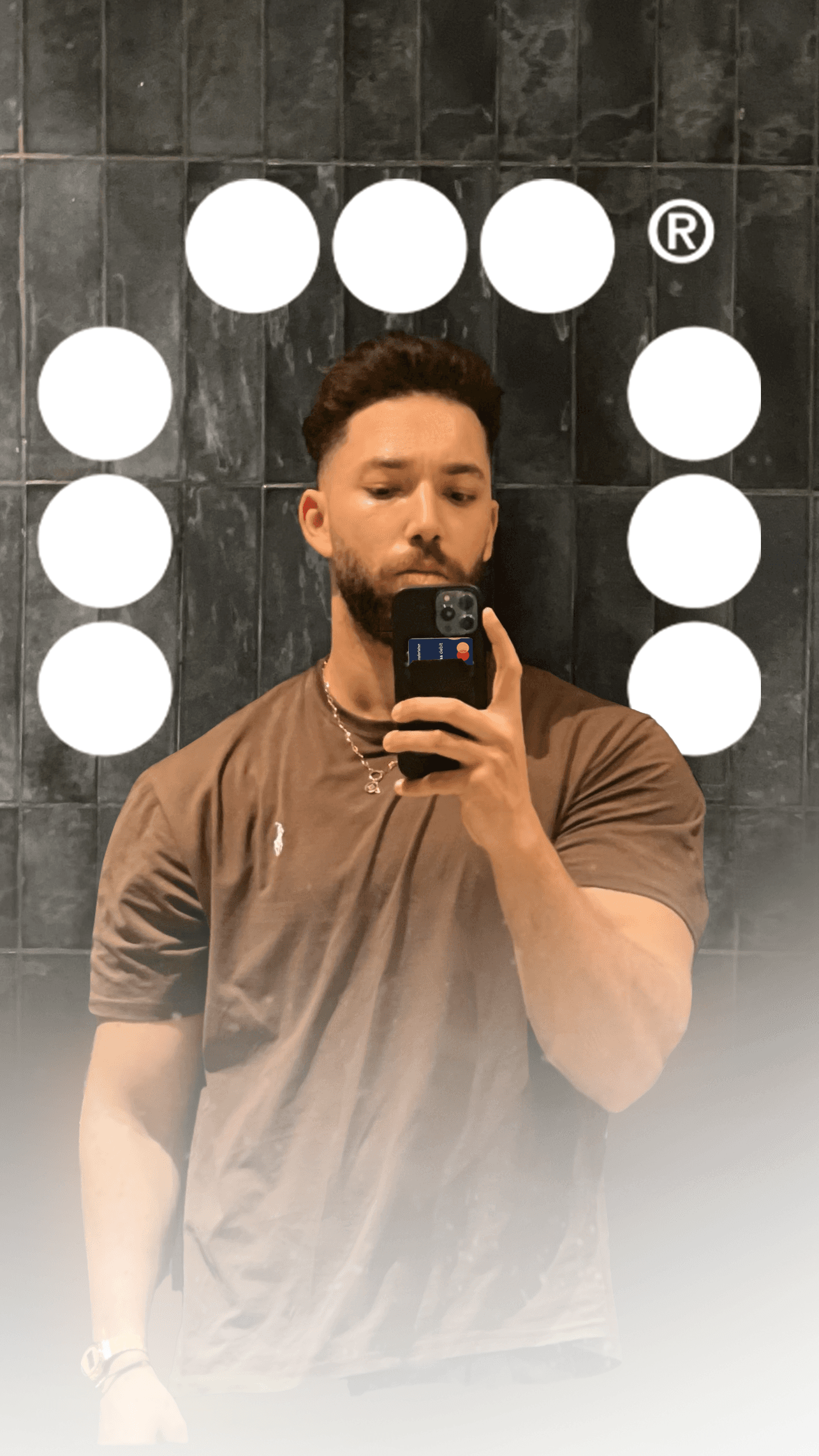 Minimal studio portrait of a confident woman in a white shirt, arms crossed, on a soft gray background.