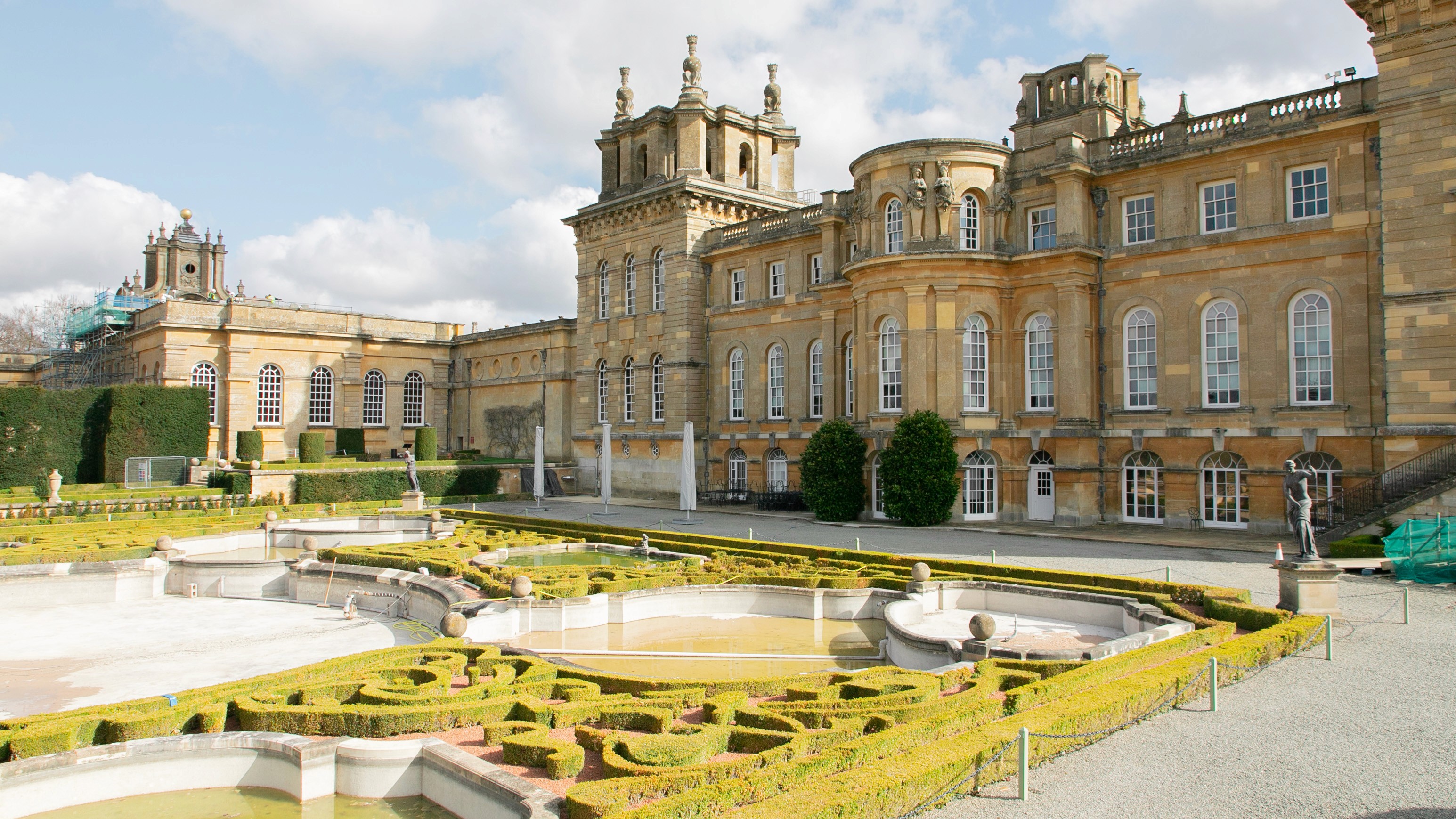 Two classic volkswagen beetles, one green, one cream.
