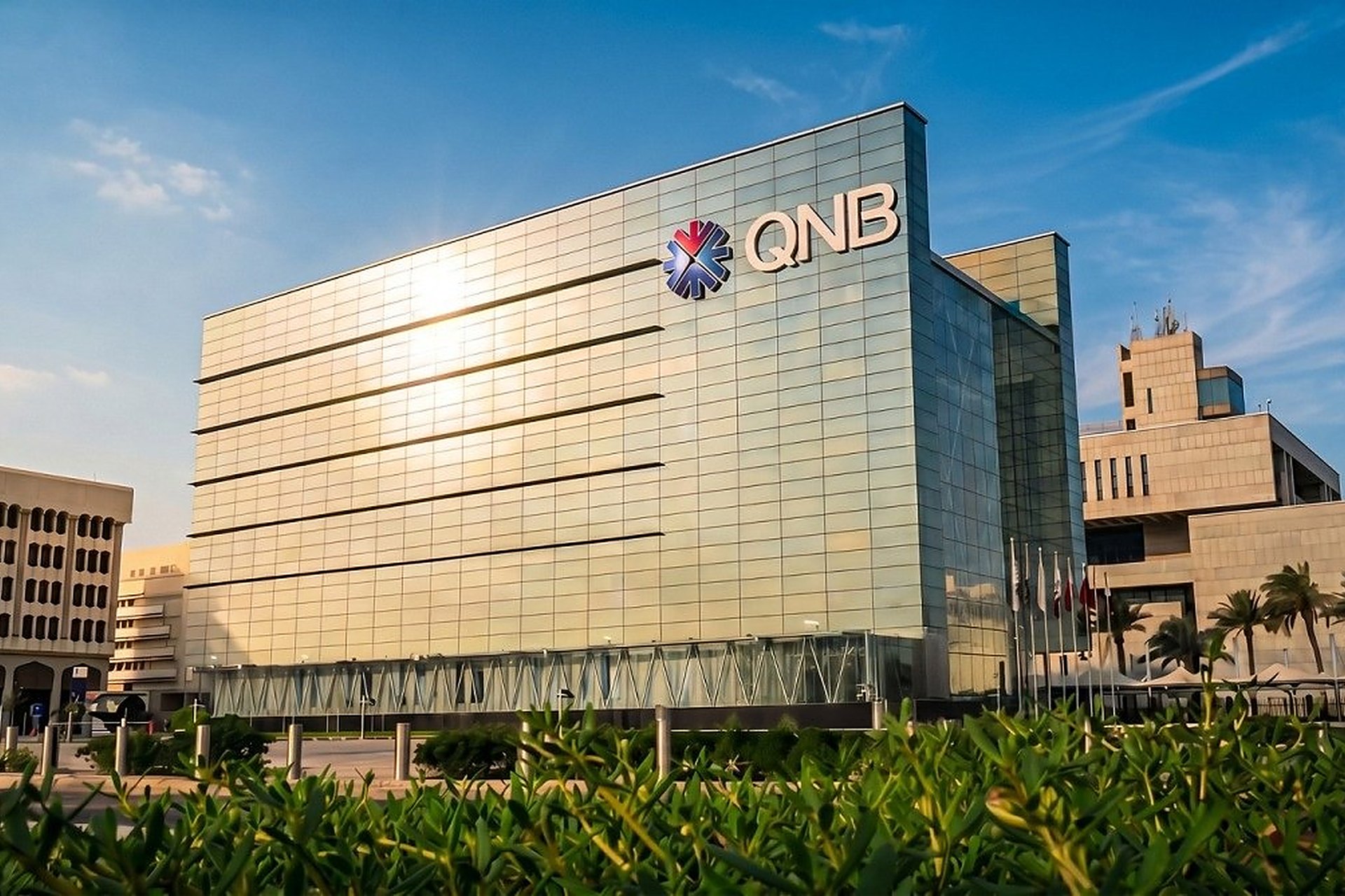 Le siège de QNB à Doha, au Qatar, sa façade de verre et son logo sous le soleil, l'une des deux banques qui accueillent les nouveaux arrivants