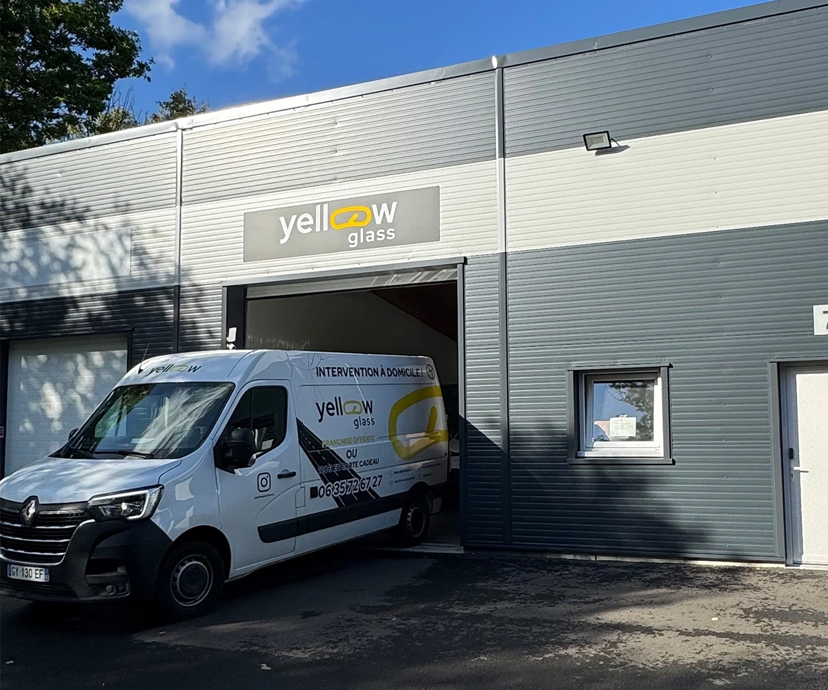 Fourgon Renault jaune de Yellow Glass devant un bâtiment avec logo. Service de vitrerie et intervention