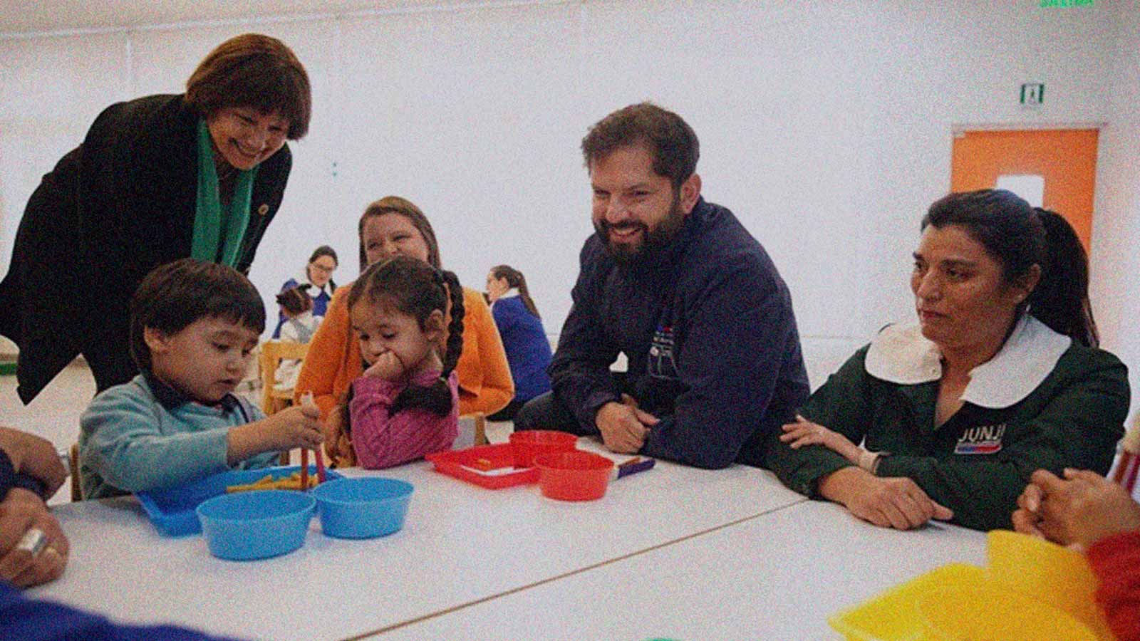 Foto que muestra al Presidente Gabriel Boric compartiendo en una mesa con niños de un jardín infantil en la columna de opinión Sala cuna sin letra chica de IdeaPaís.