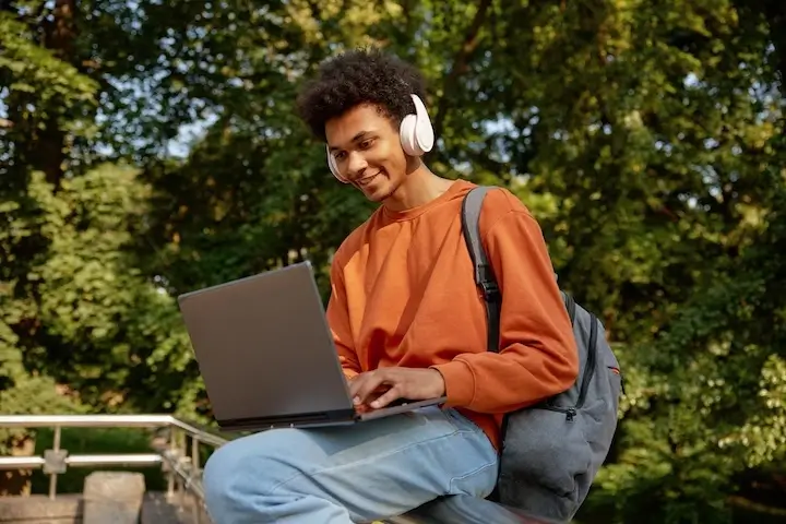 student outside class on laptop