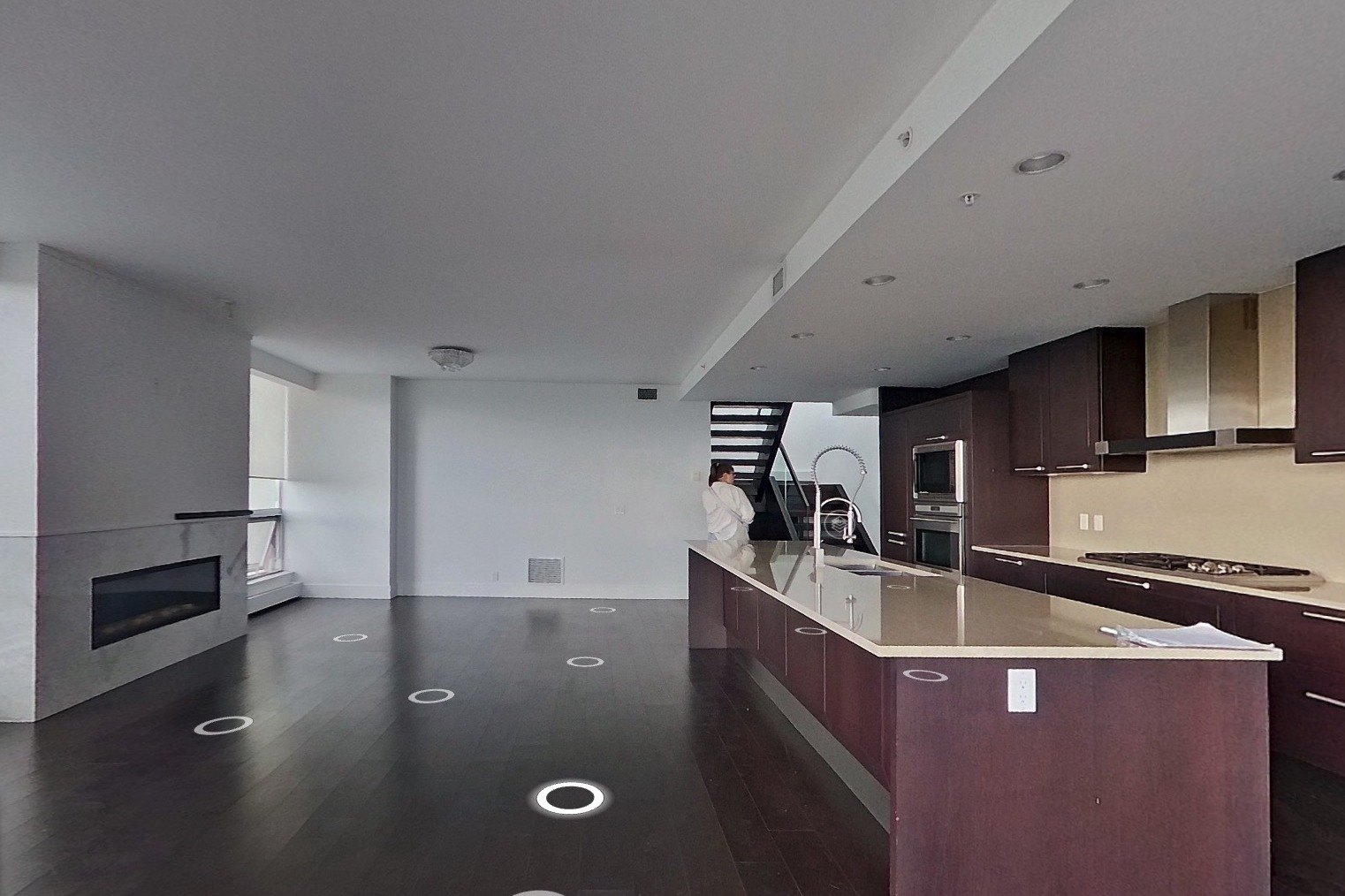 Eau Claire great room before: dark floors, original fireplace and kitchen
