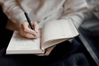 high school student reviewing academic social science journal articles at a library desk