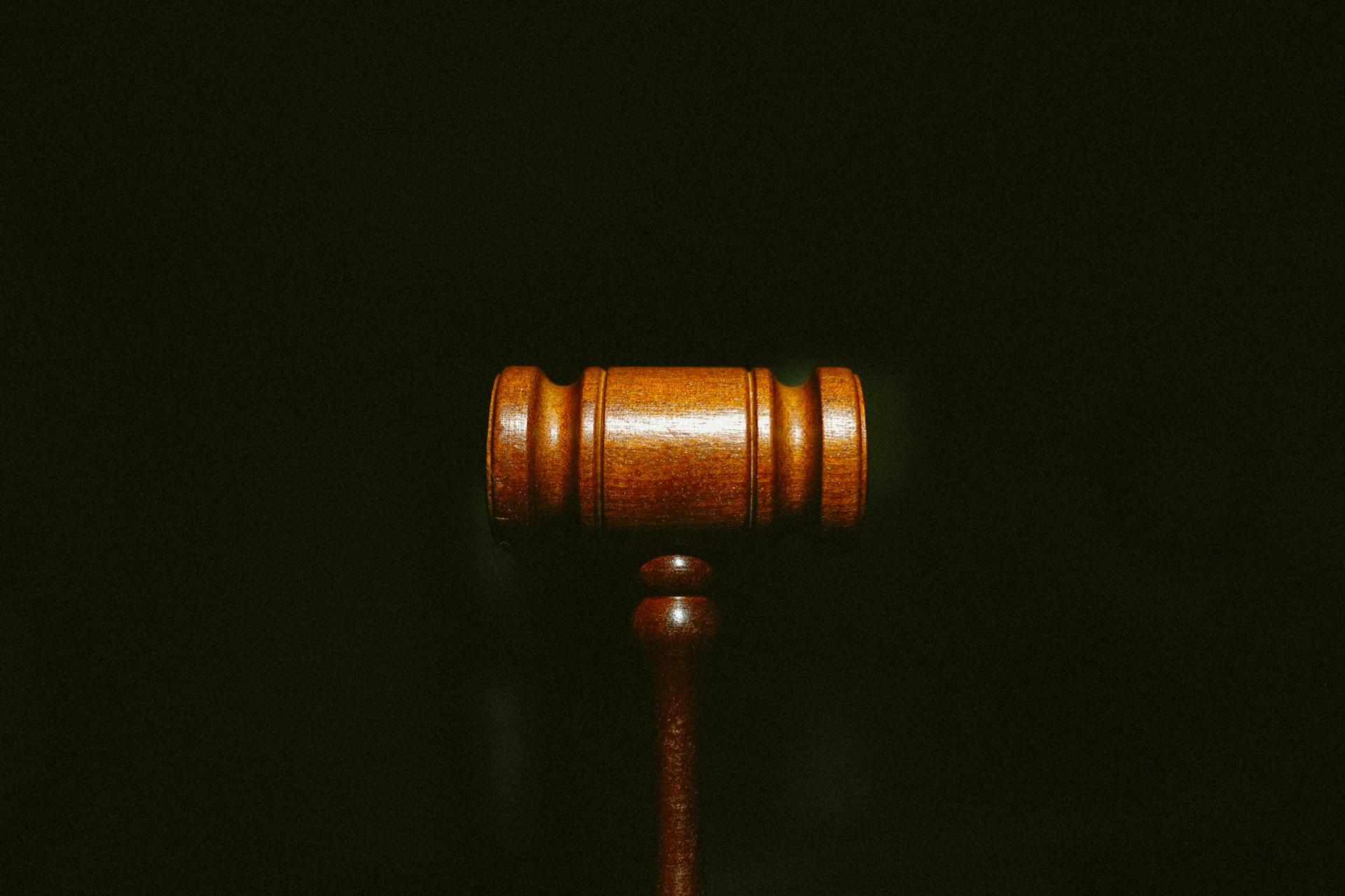 A gavel in front of a dark background