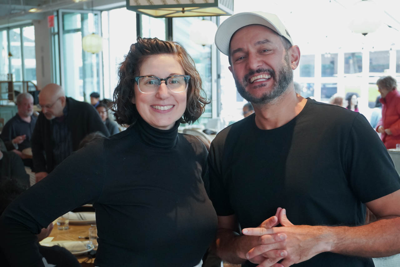 two people smiling at the camera in a restaurant