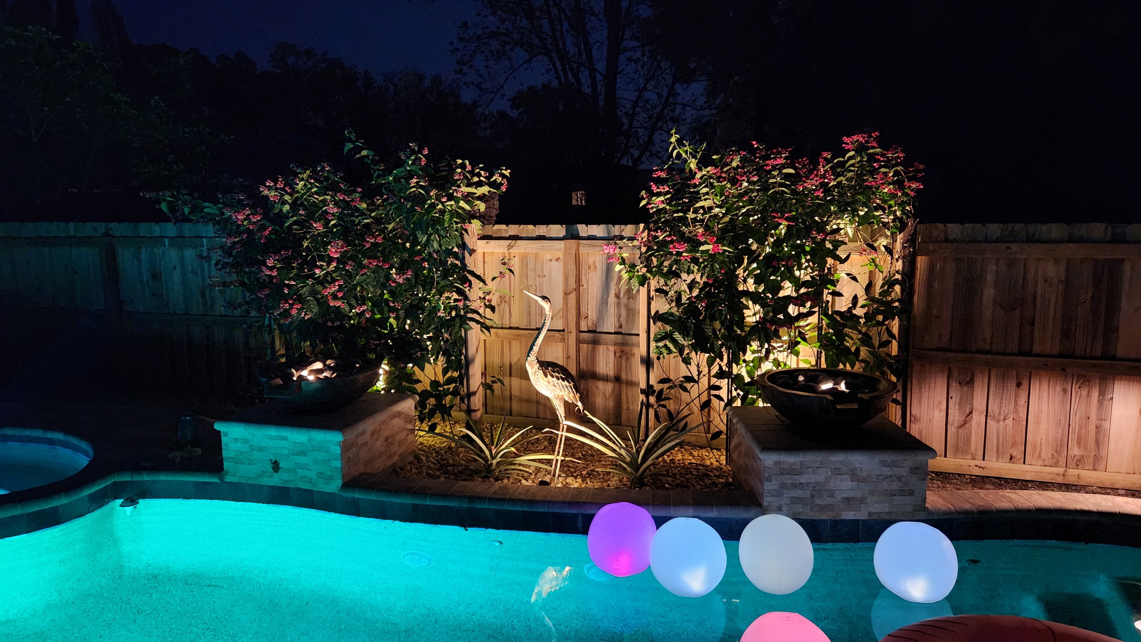 Backyard pool and seating area enhanced with ambient outdoor living lighting