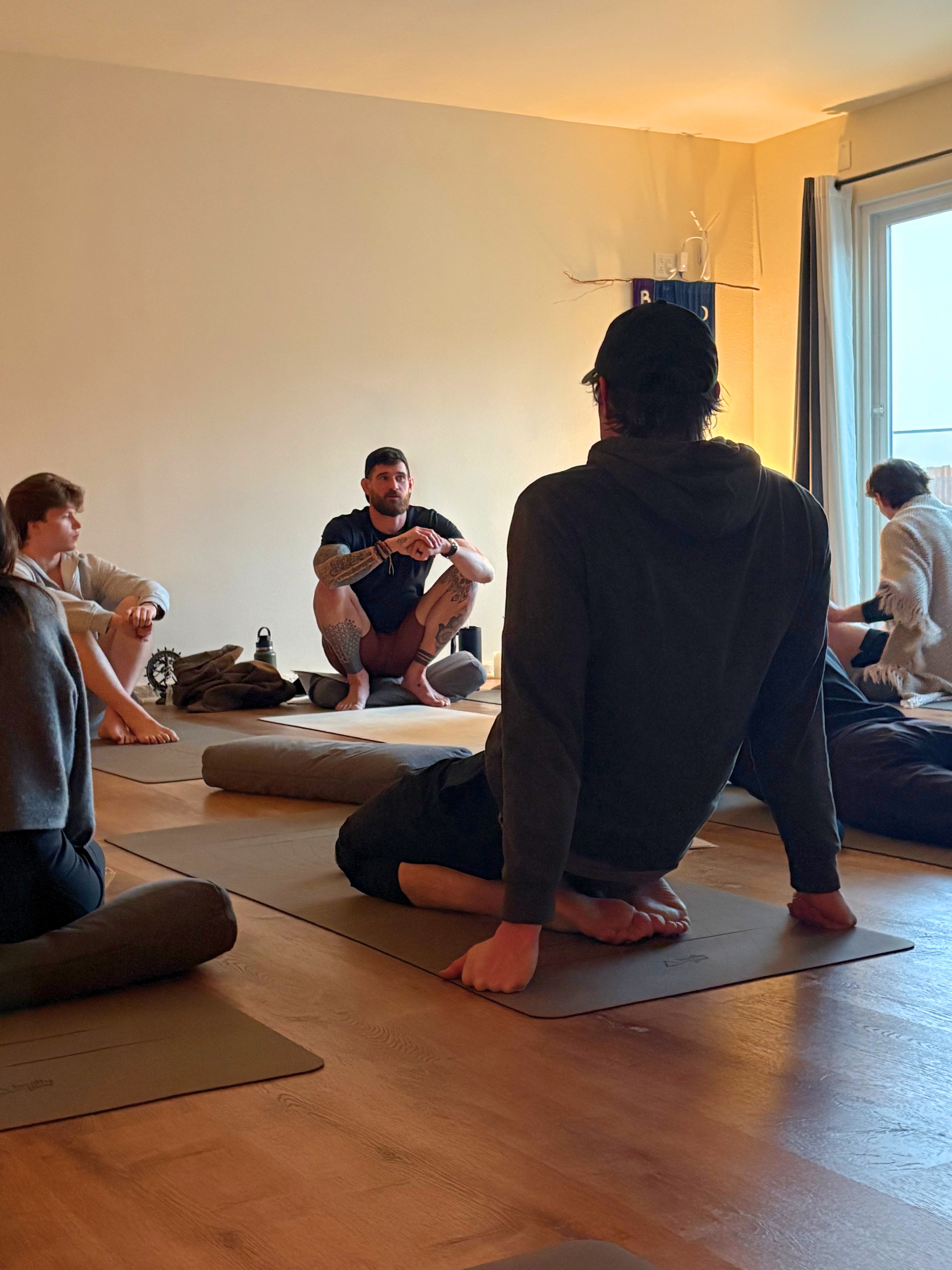 Group yoga retreat participants practicing together in a jungle studio.