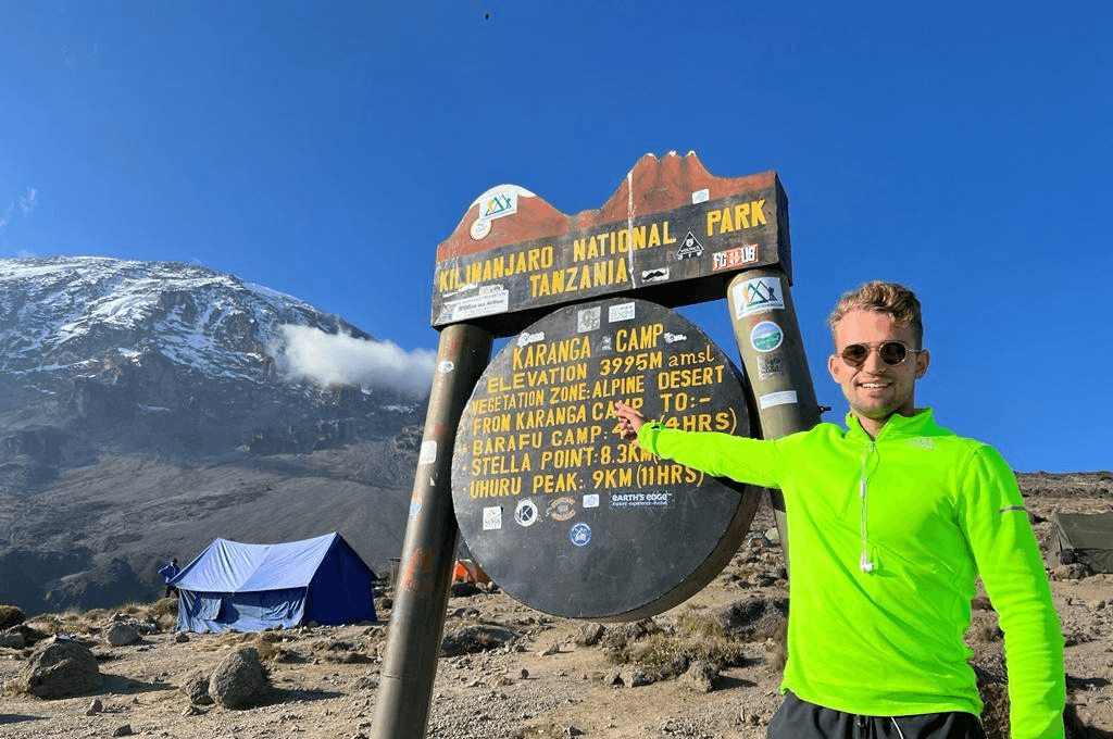 Lukas Kazimierski am Gipfelschild des Uhuru Peak auf dem Kilimandscharo, 5.895 Meter
