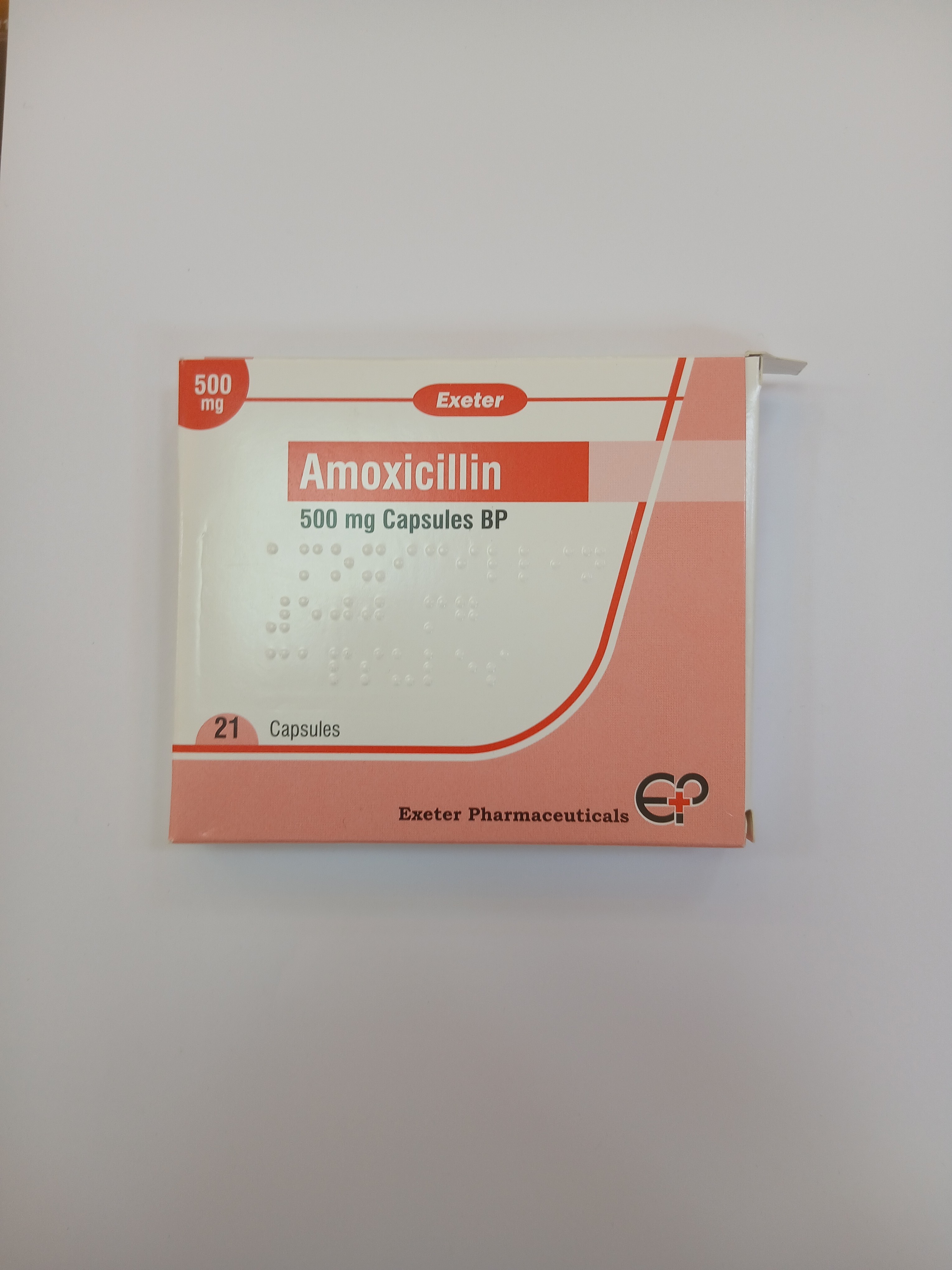White and red cardboard box packaging displays text indicating it contains twenty-one capsules, with a small logo and text printed on the front.