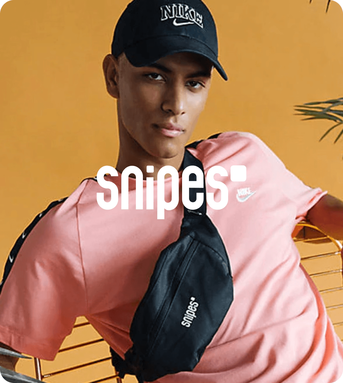 man wearing a hat and a pink shirt with the snipes logo overlayed