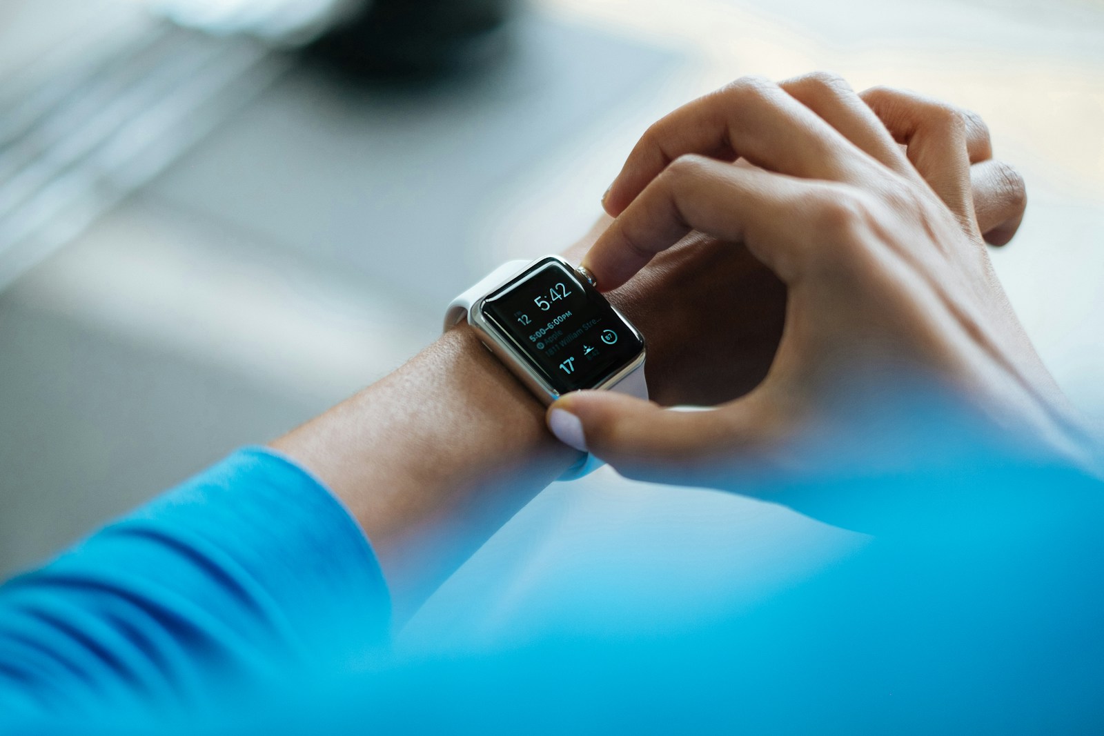 Nahaufnahme einer Person in Sportkleidung, die ihre Smartwatch bedient.