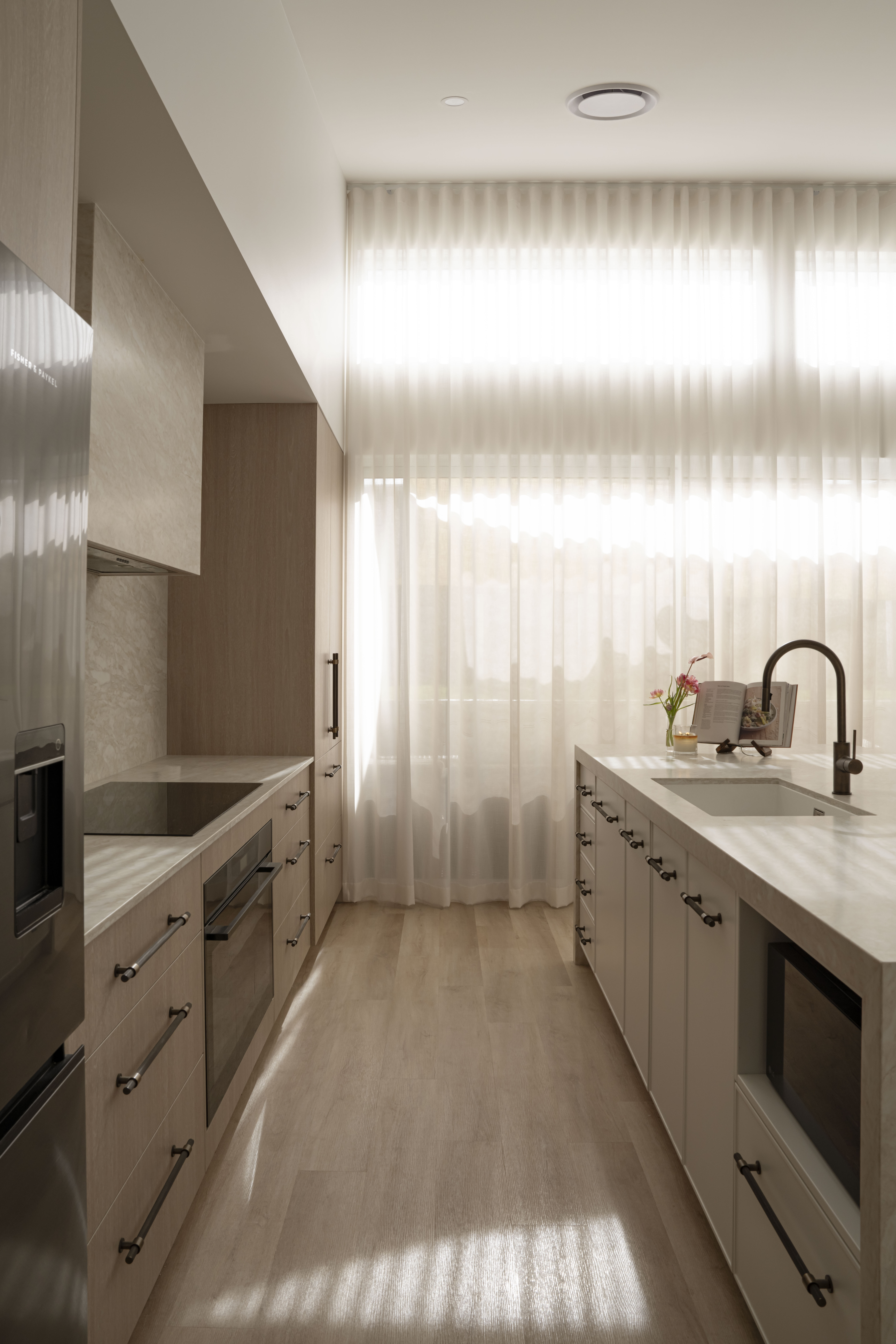 Light-filled galley kitchen in Anna Bay with stone benchtops and timber cabinetry