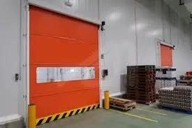 Puerta rápida metálica color rojo, compacta y eficiente. Mejora el flujo de materiales, sella el ambiente y reduce el consumo energético en espacios interiores.